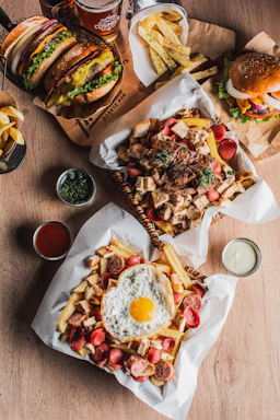 Heart-shaped egg on fries with sausages and burgers