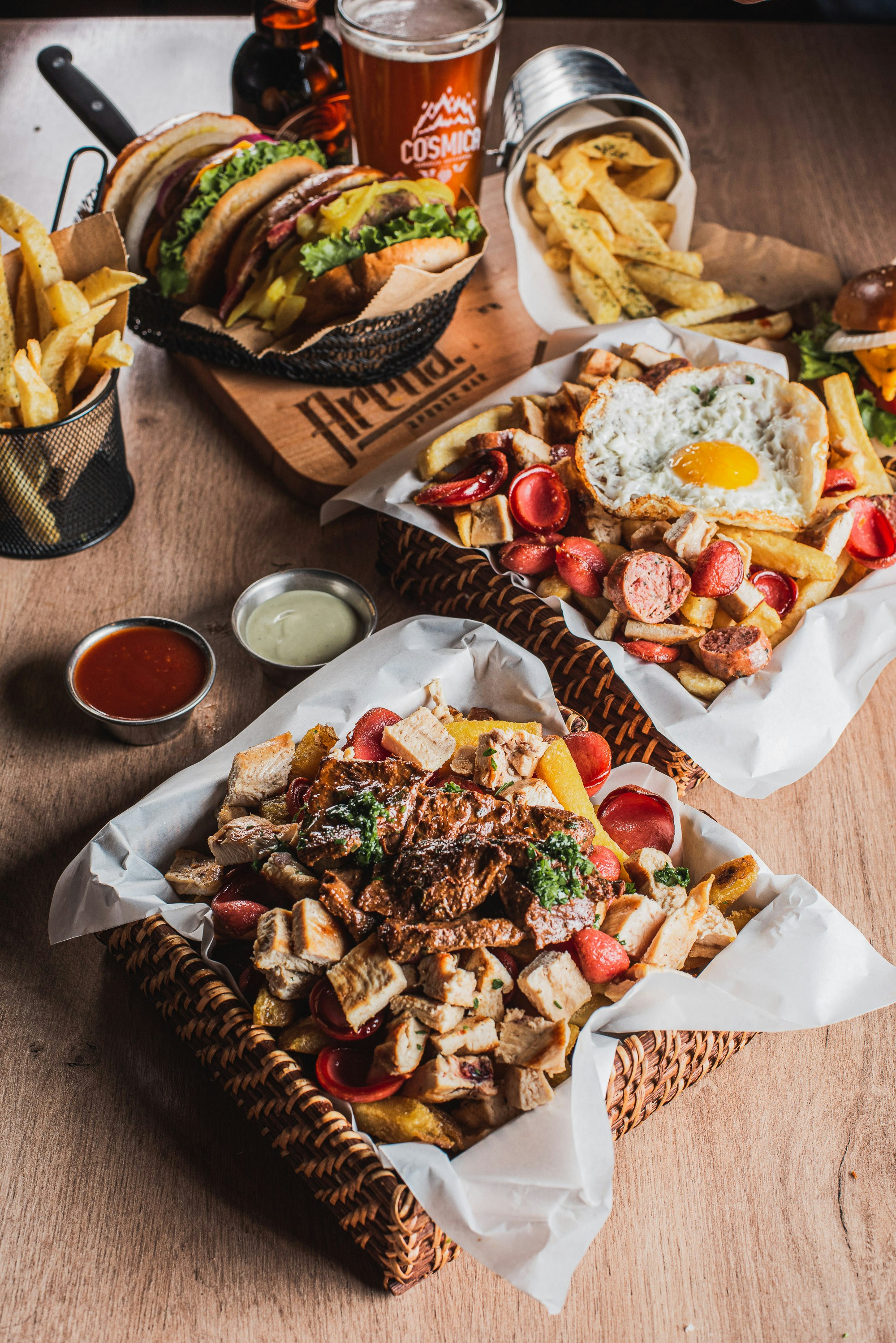 Two baskets of loaded fries with meat and toppings.