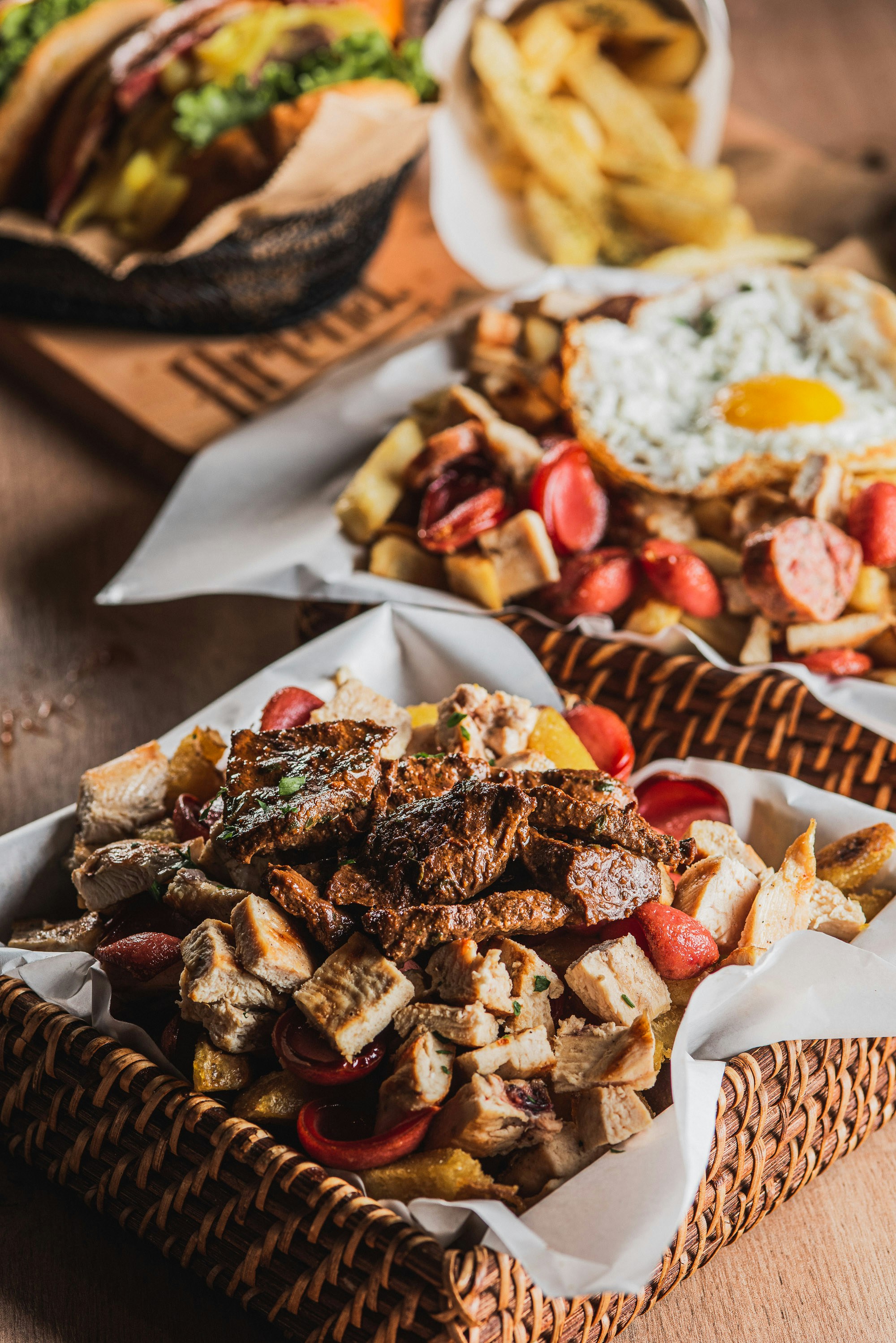 Basket of meat, fries, and sausages with fried egg