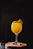 A bright orange cocktail with fruit garnish