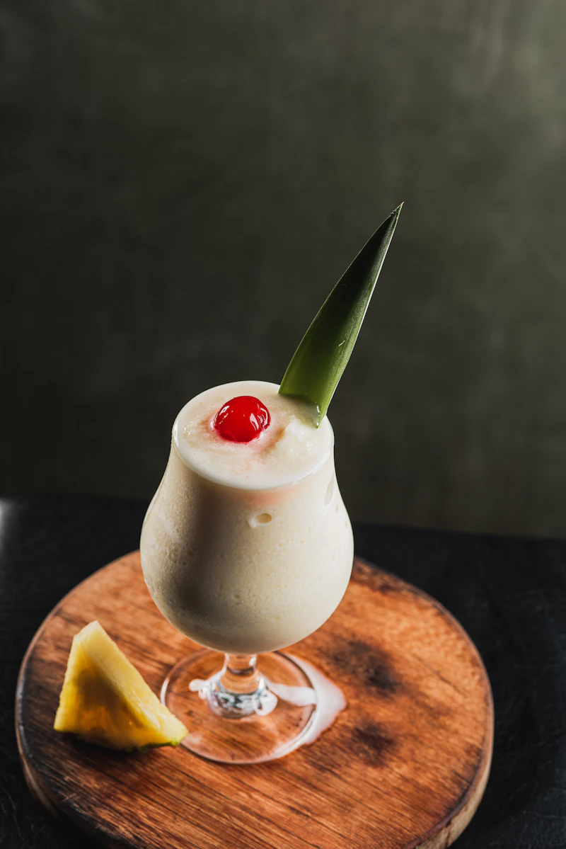 Cremig-weißes Slush-Eis mit einem Stück Ananas am Becherrand