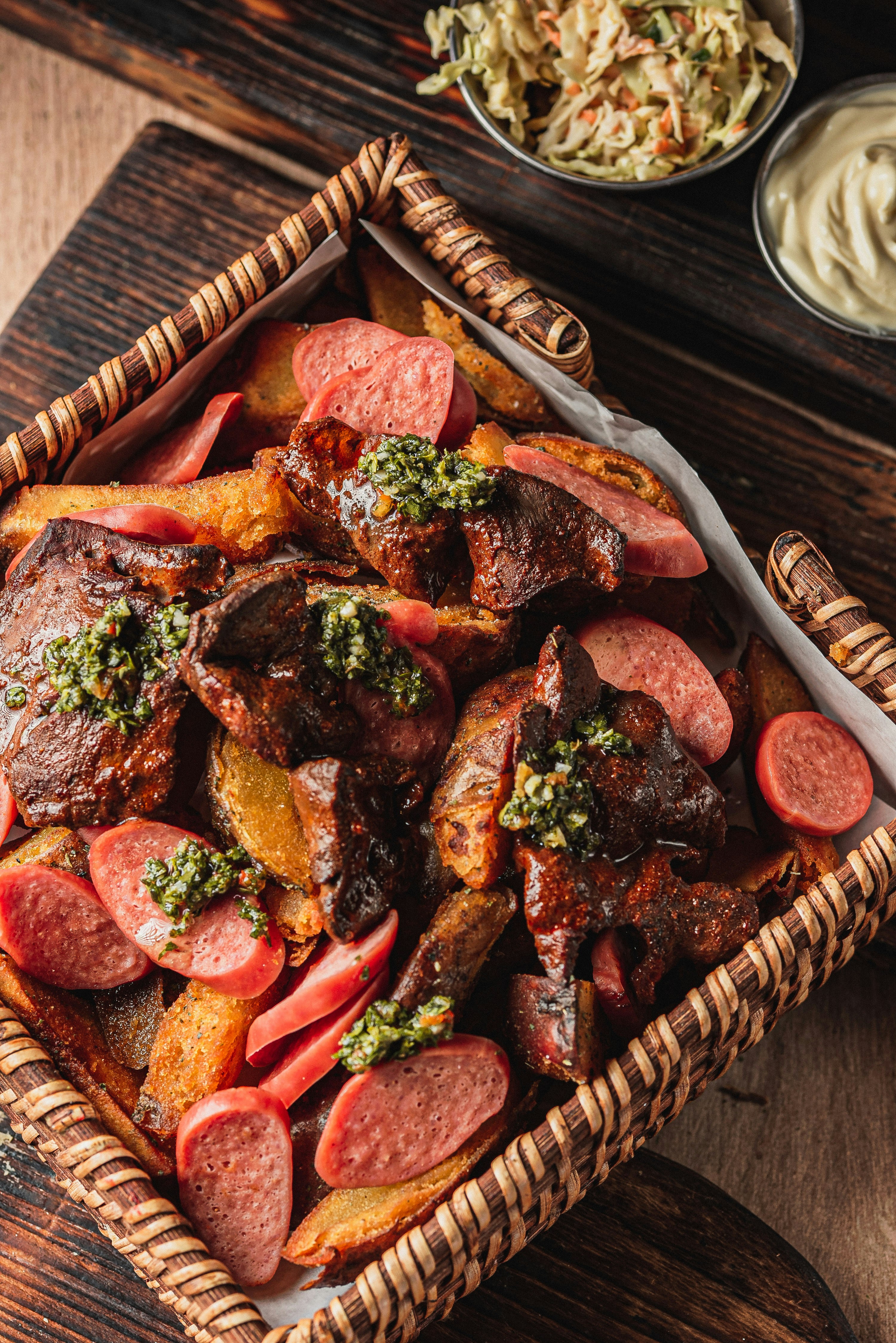 Grilled meat and sausage platter with fries and sauce