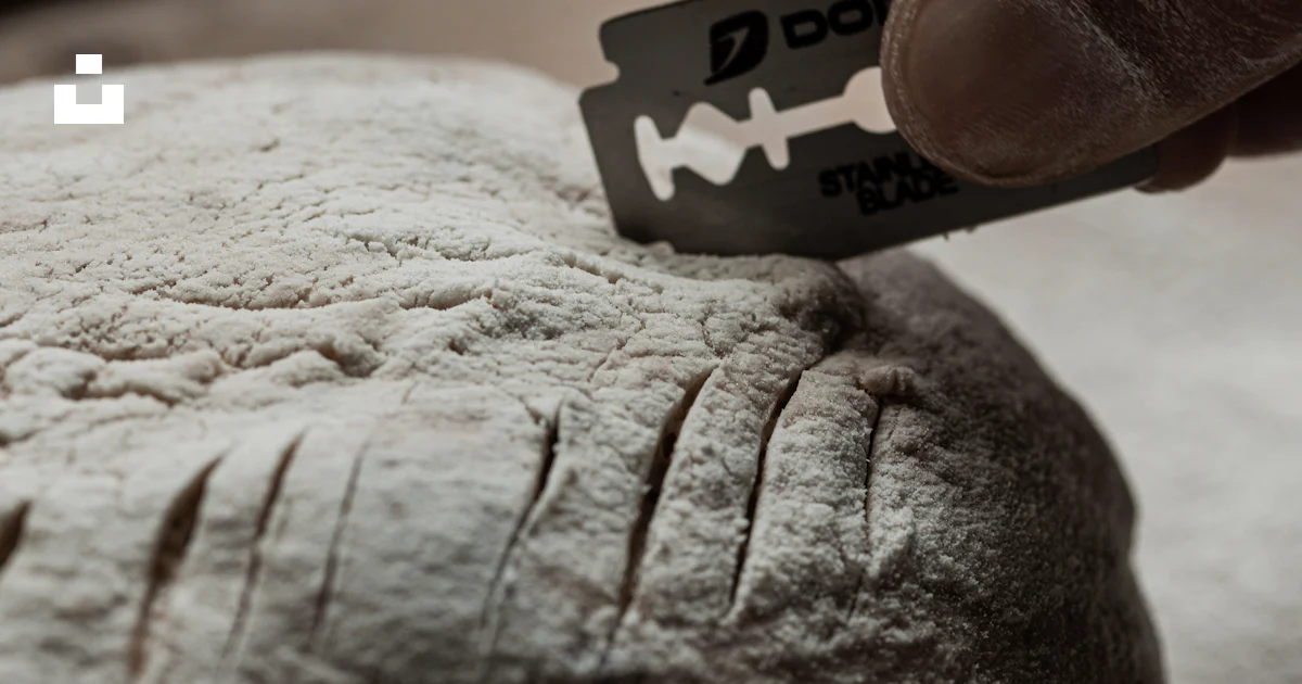 Baker scores dough with a razor blade photo – Free Hand Image on Unsplash
