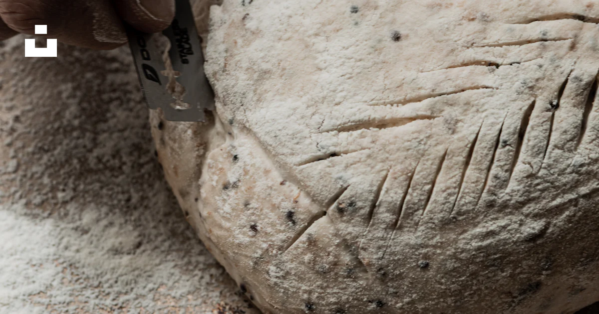 Baker scoring bread dough with a razor blade. photo – Free Hand Image ...