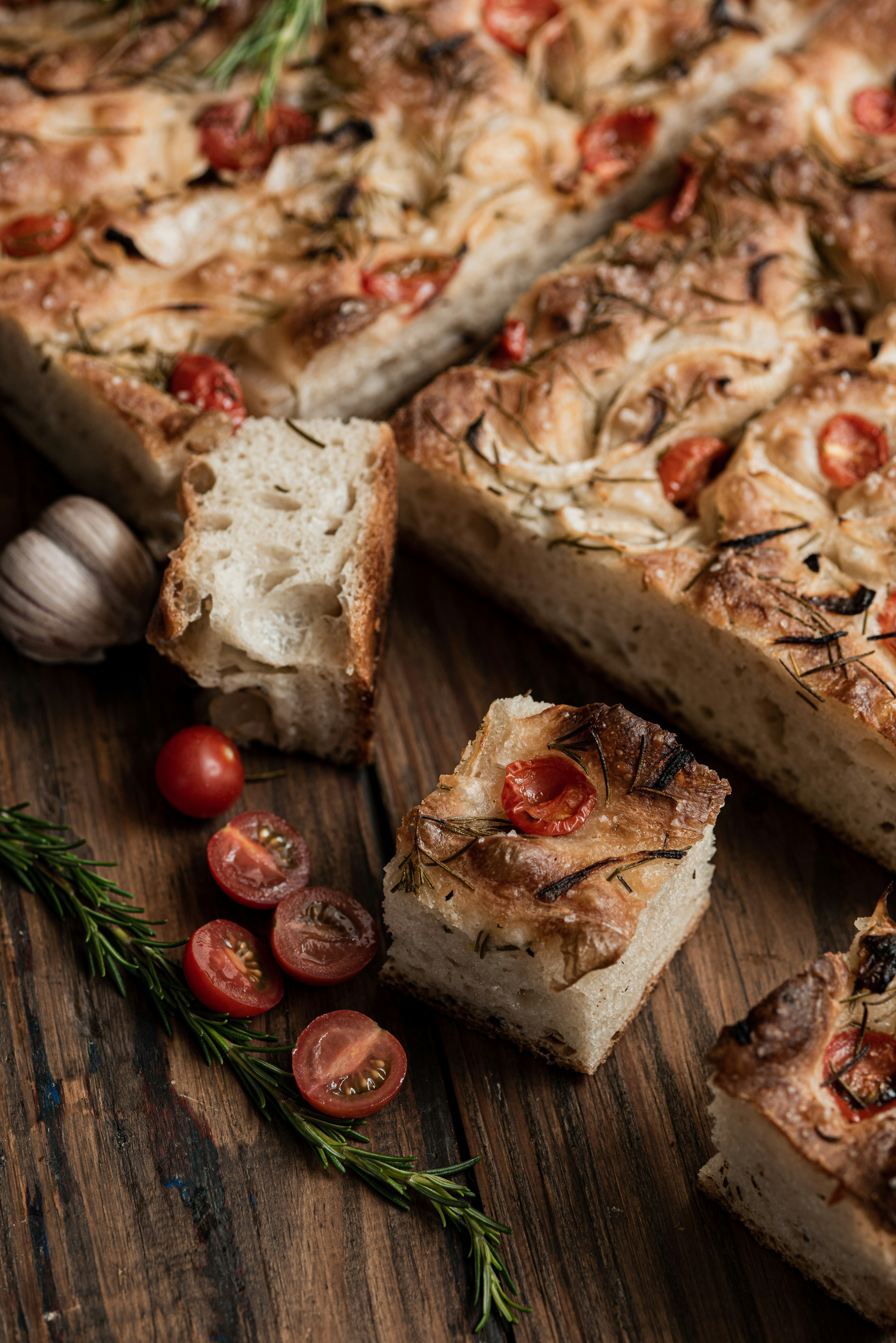 Focaccia bread with tomatoes and rosemary on wood