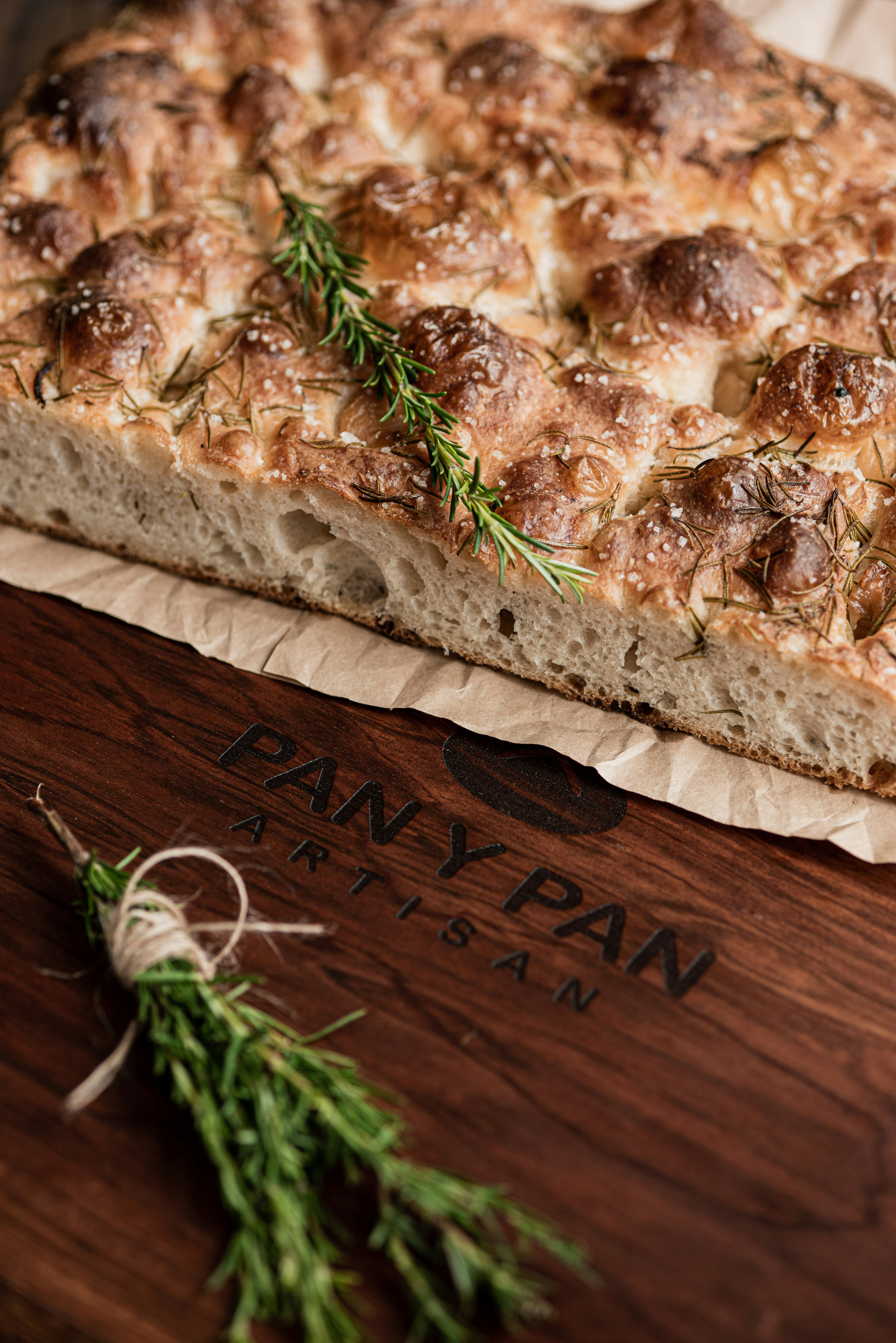 Freshly baked focaccia bread with rosemary on a wooden board