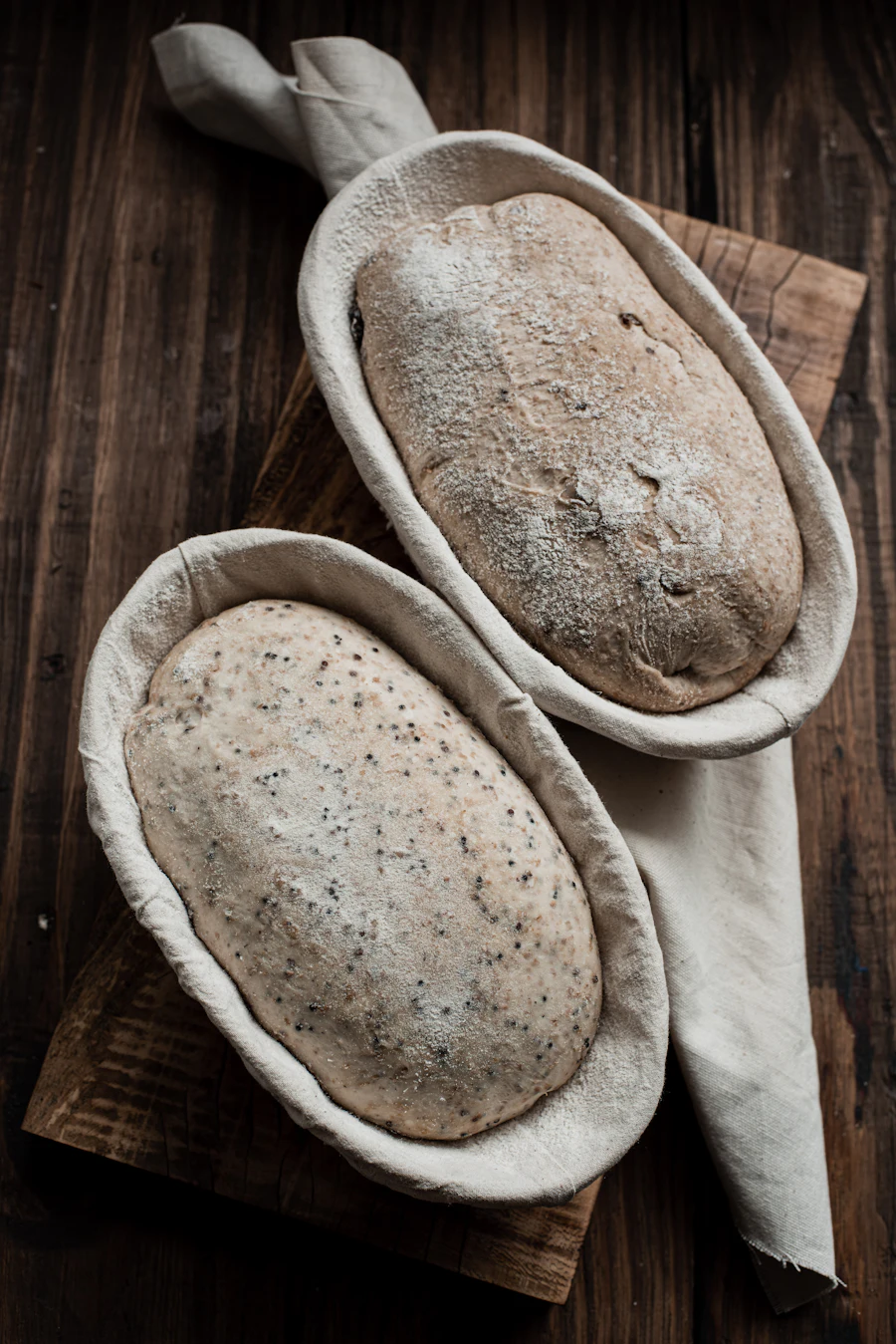 Two loaves of dough rising in proofing baskets