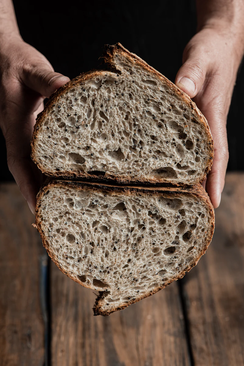 Mains tenant une miche au levain tout juste sortie du four