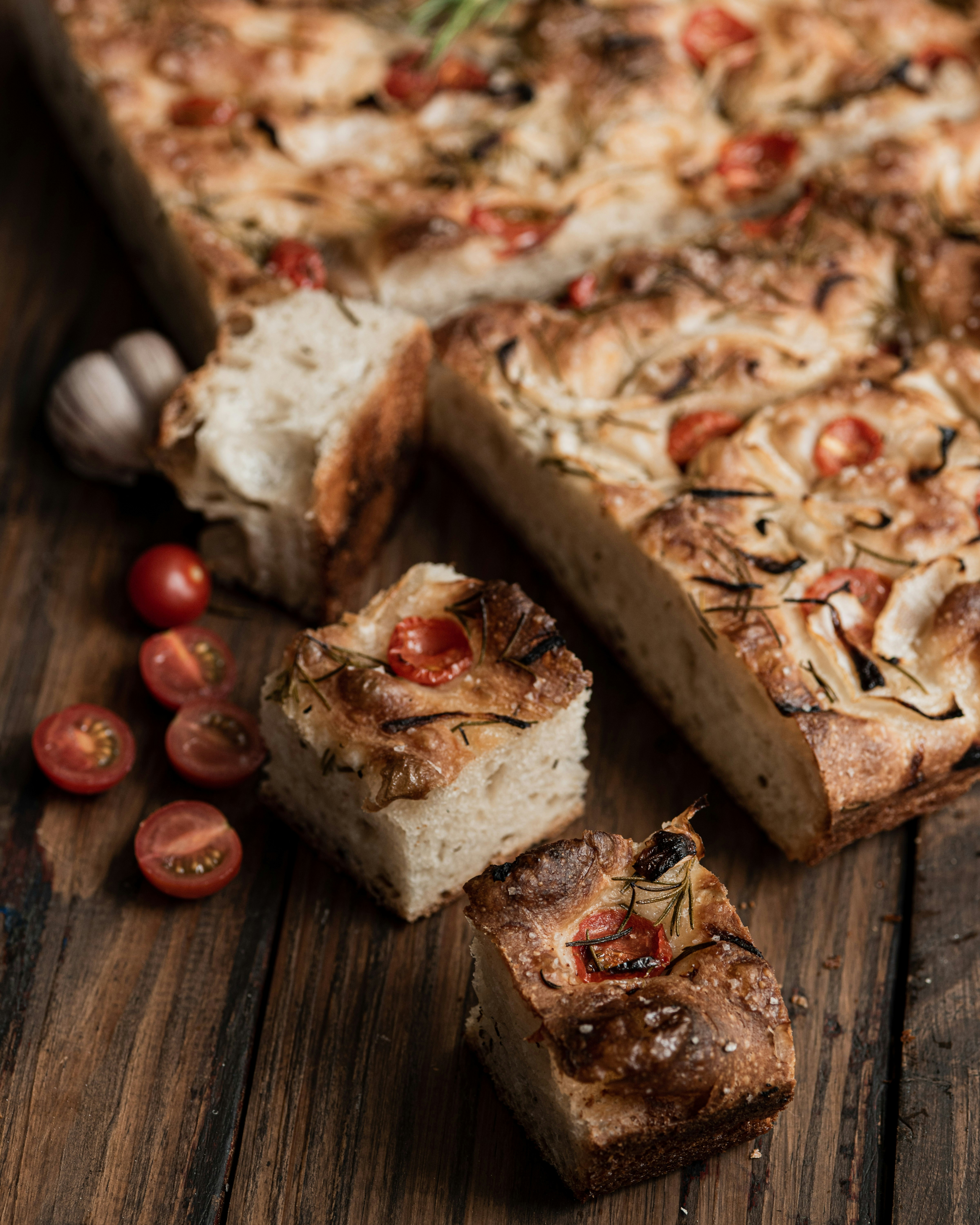 Focaccia bread with tomatoes and onions on wooden table