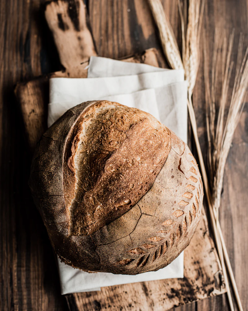 A rustic loaf of sourdough bread on a wooden board