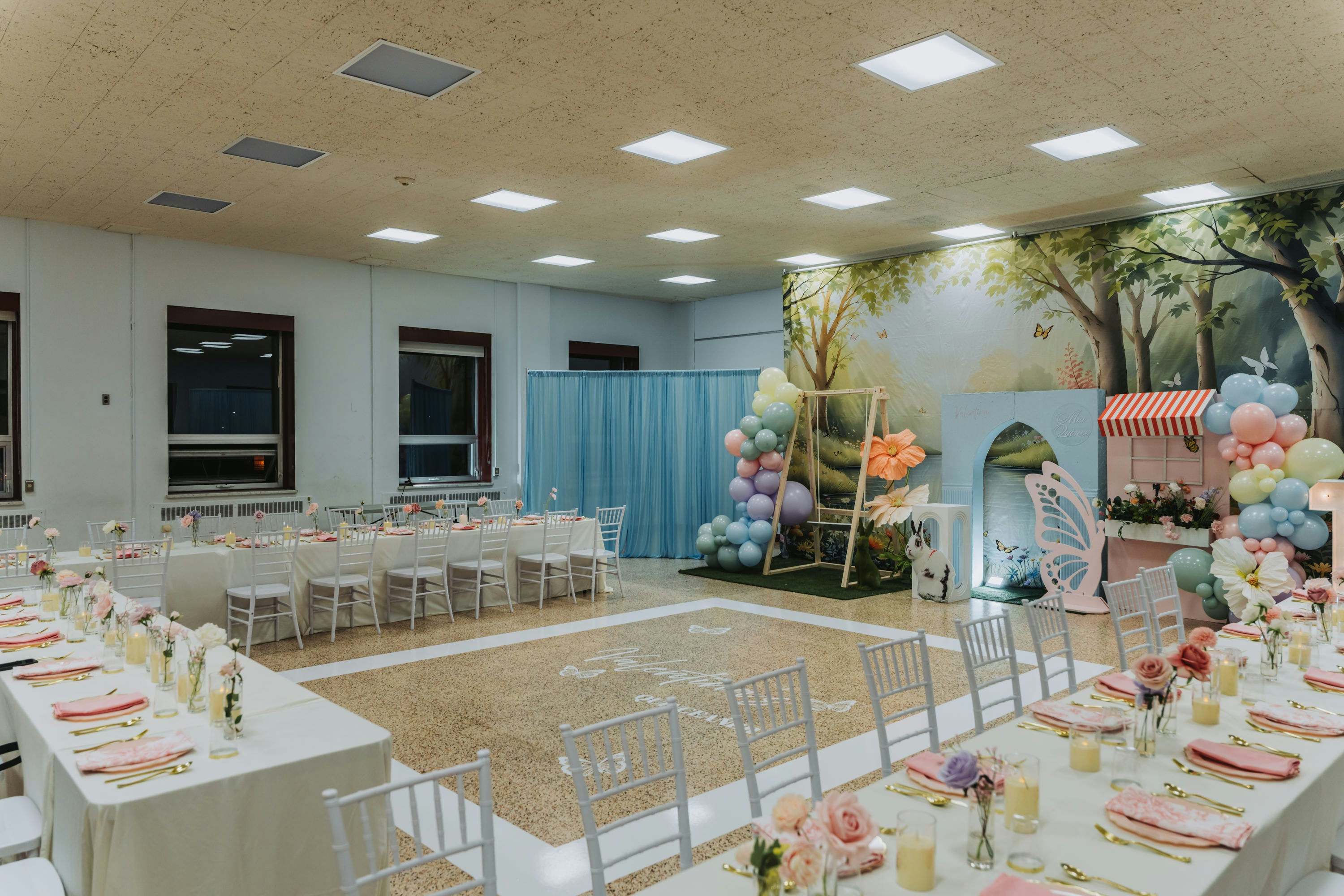 A decorated event space with tables and balloons