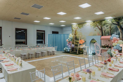 A decorated event space with tables and balloons
