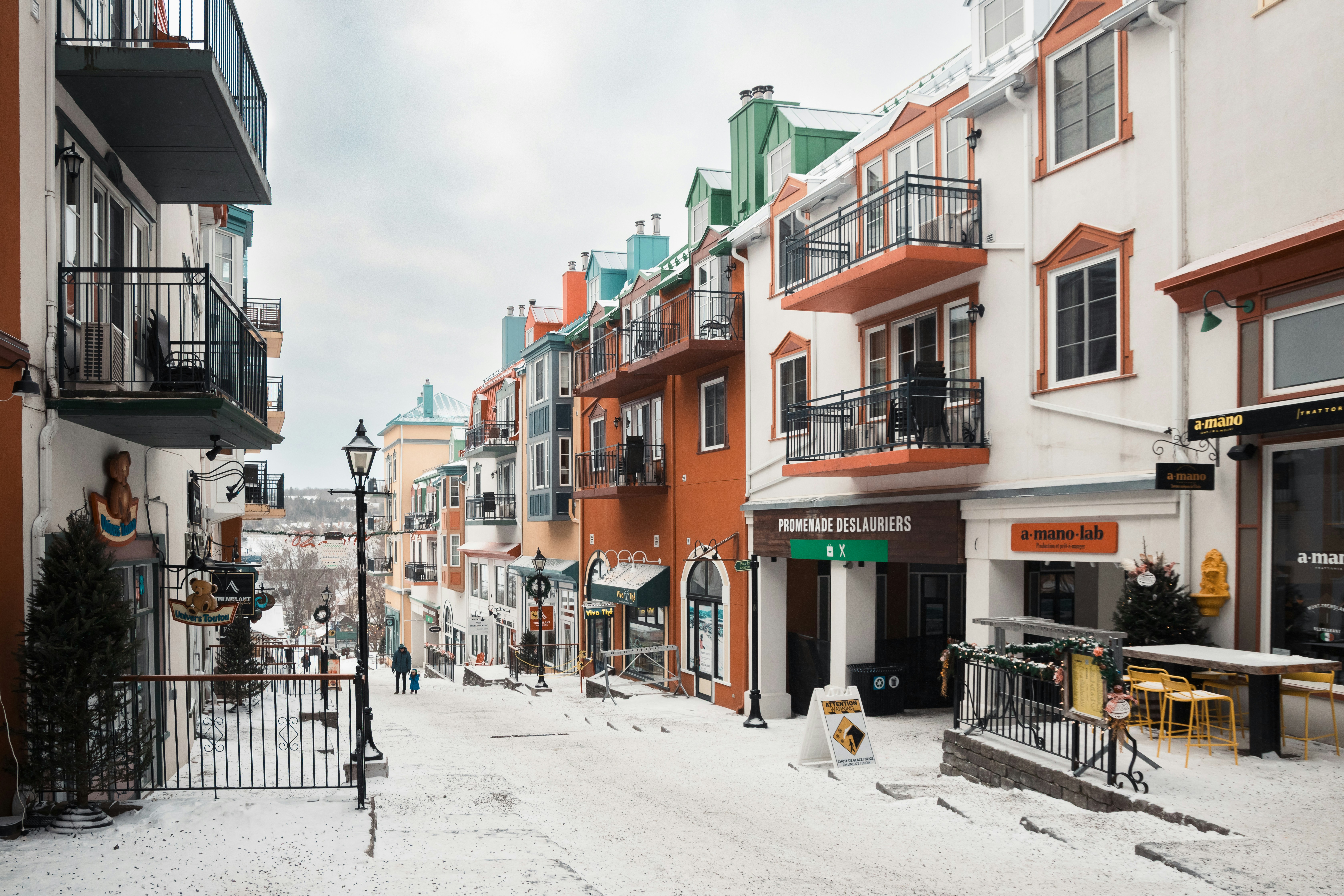Colorful buildings line a snowy street in a village.
