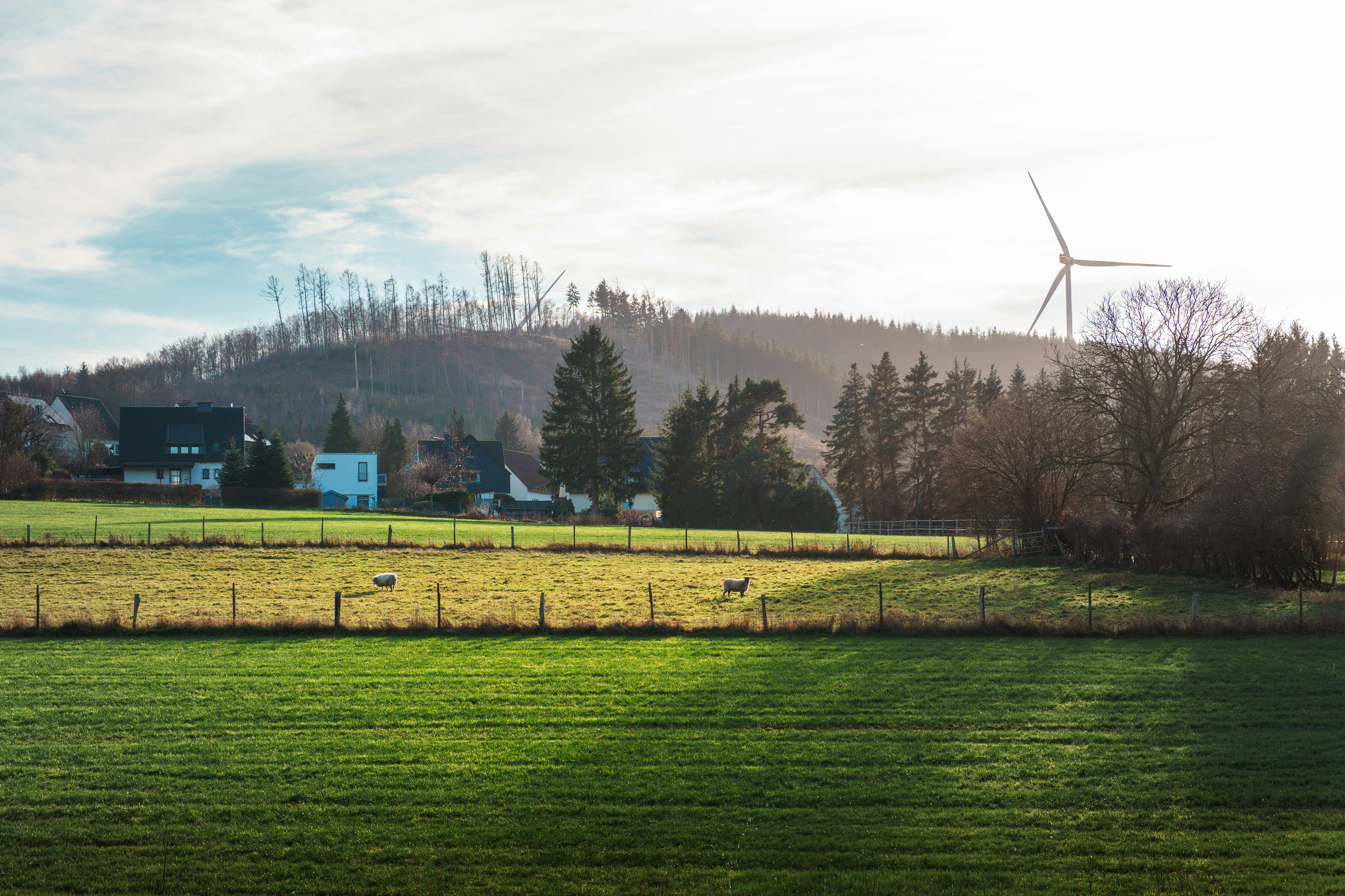 Wind turbine on a hill overlooking a village and fields