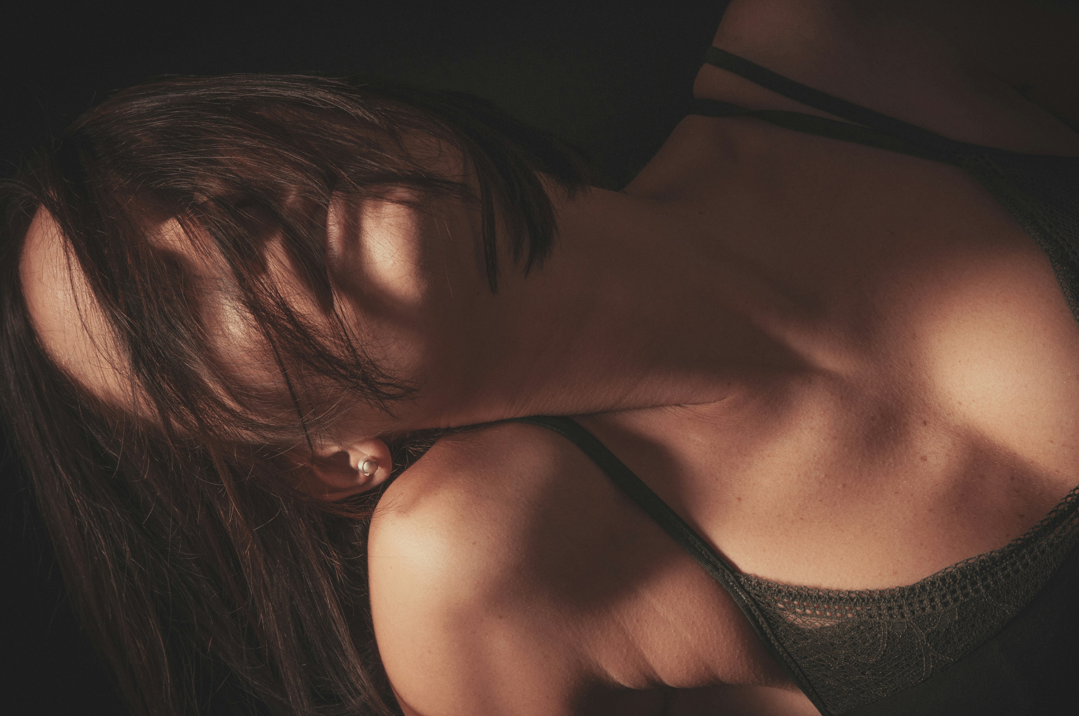 امرأة ذات شعر داكن تستريح برأسها على كتفها.