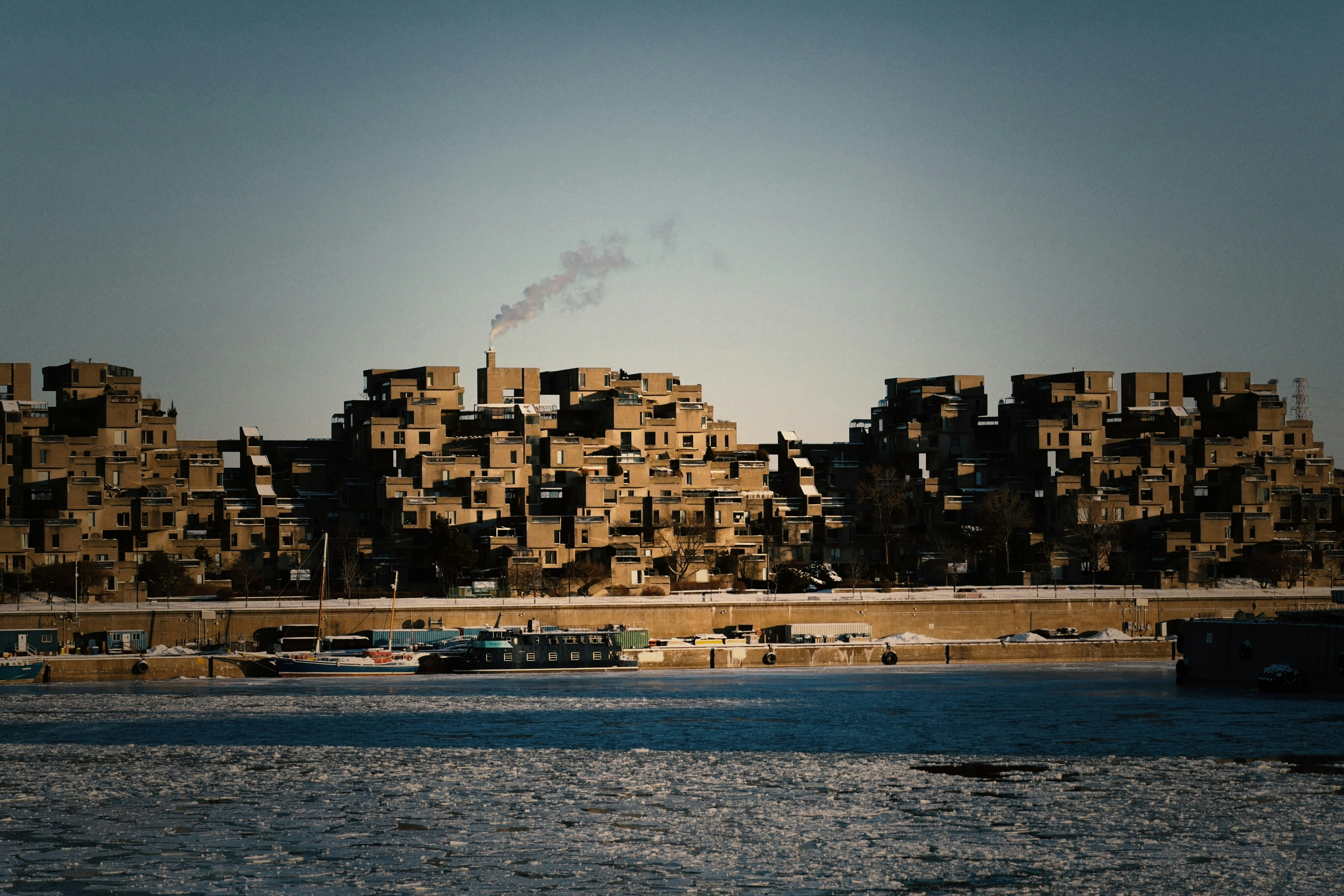Modular housing complex with smoke rising from chimney.
