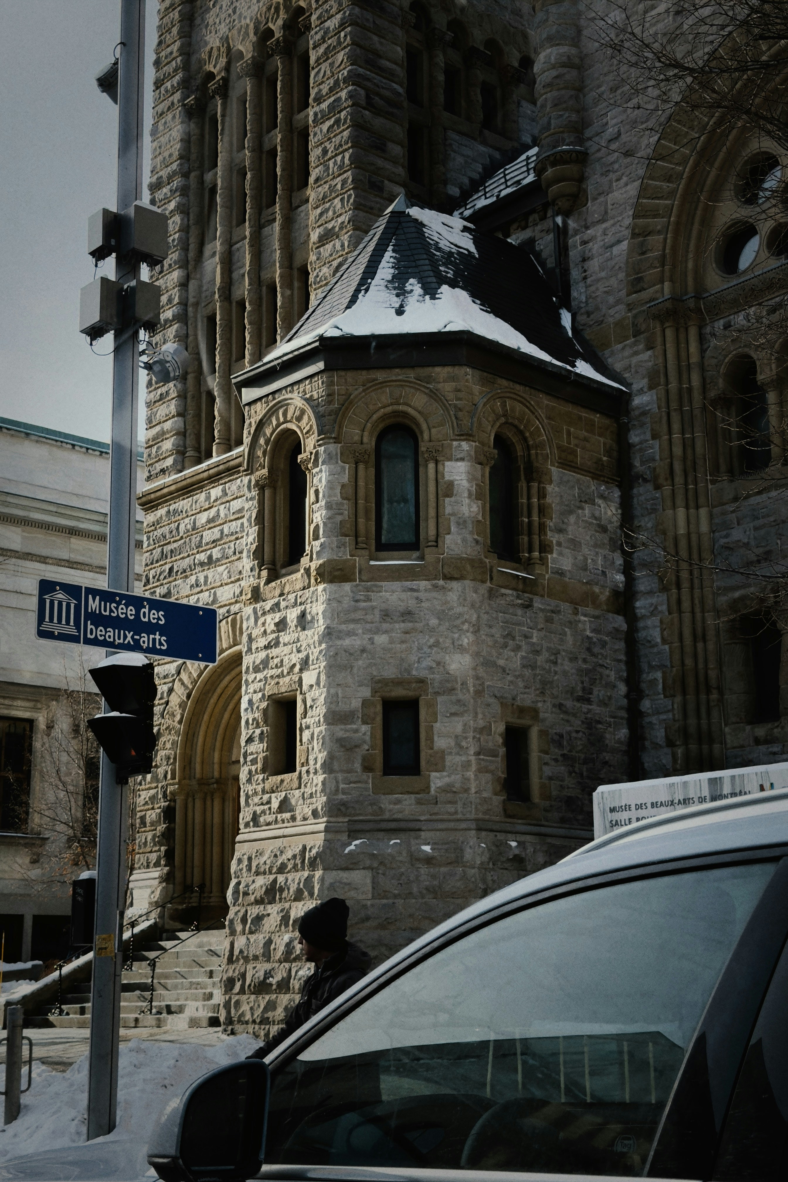 Stone building with snow and street sign