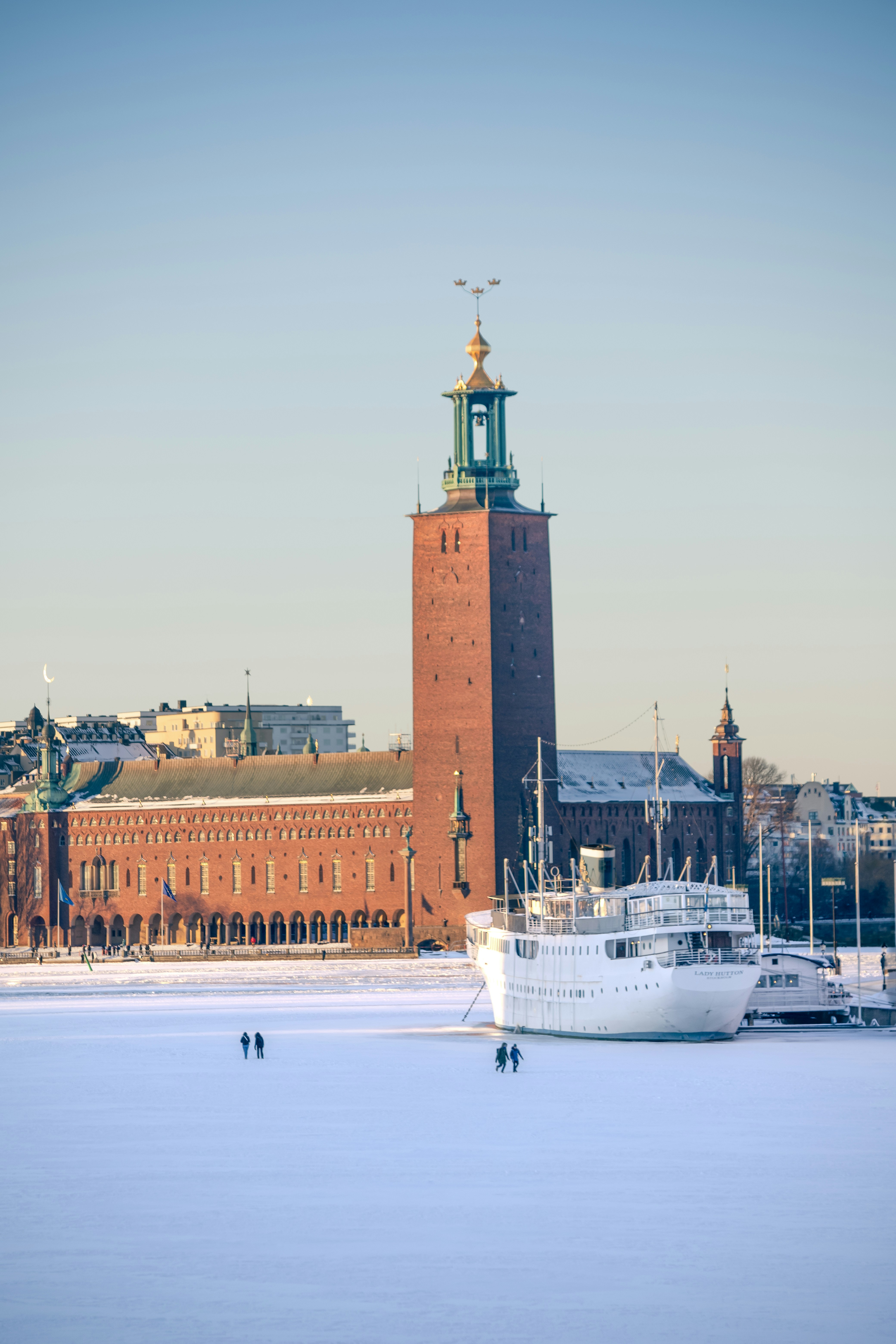 Brick tower building with a white ship in frozen water.