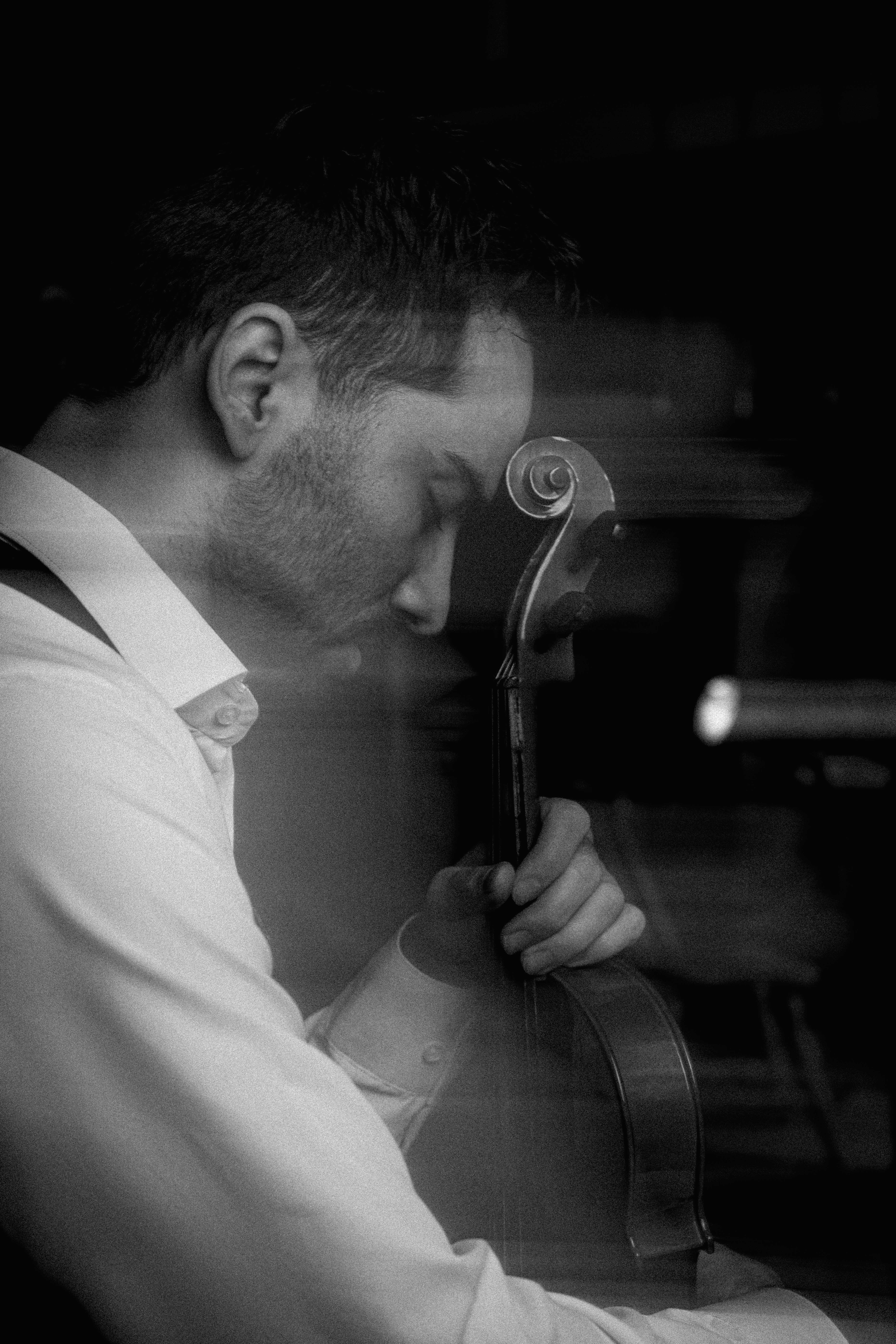 Man playing cello with eyes closed