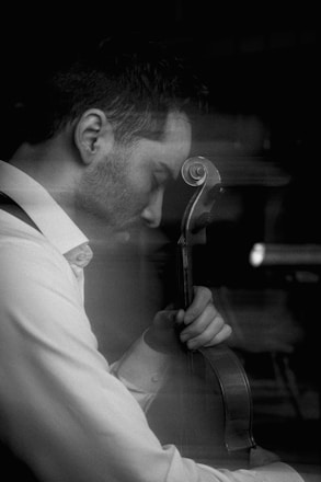 Man playing cello with eyes closed