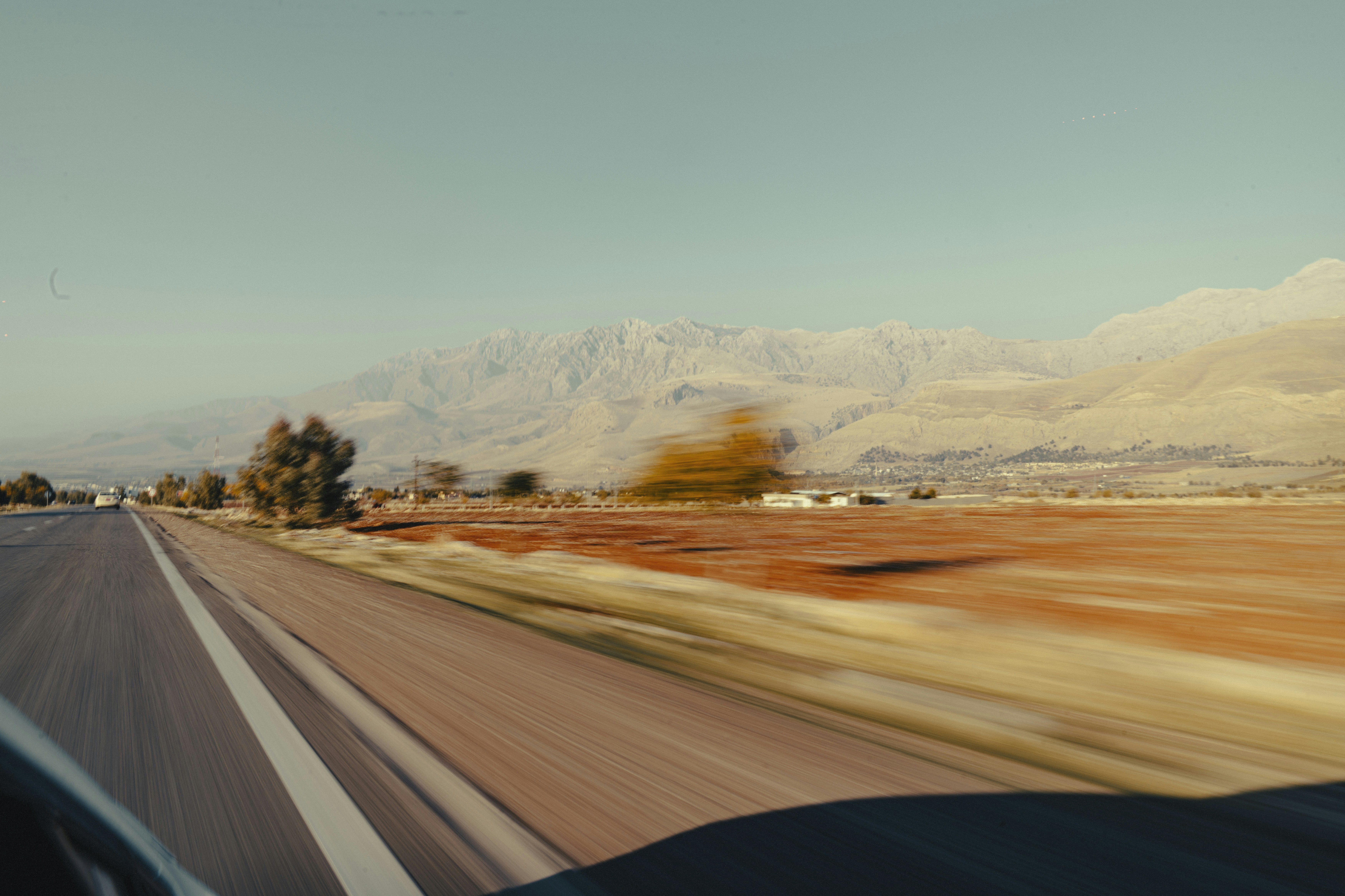 Driving on a highway towards distant mountains.