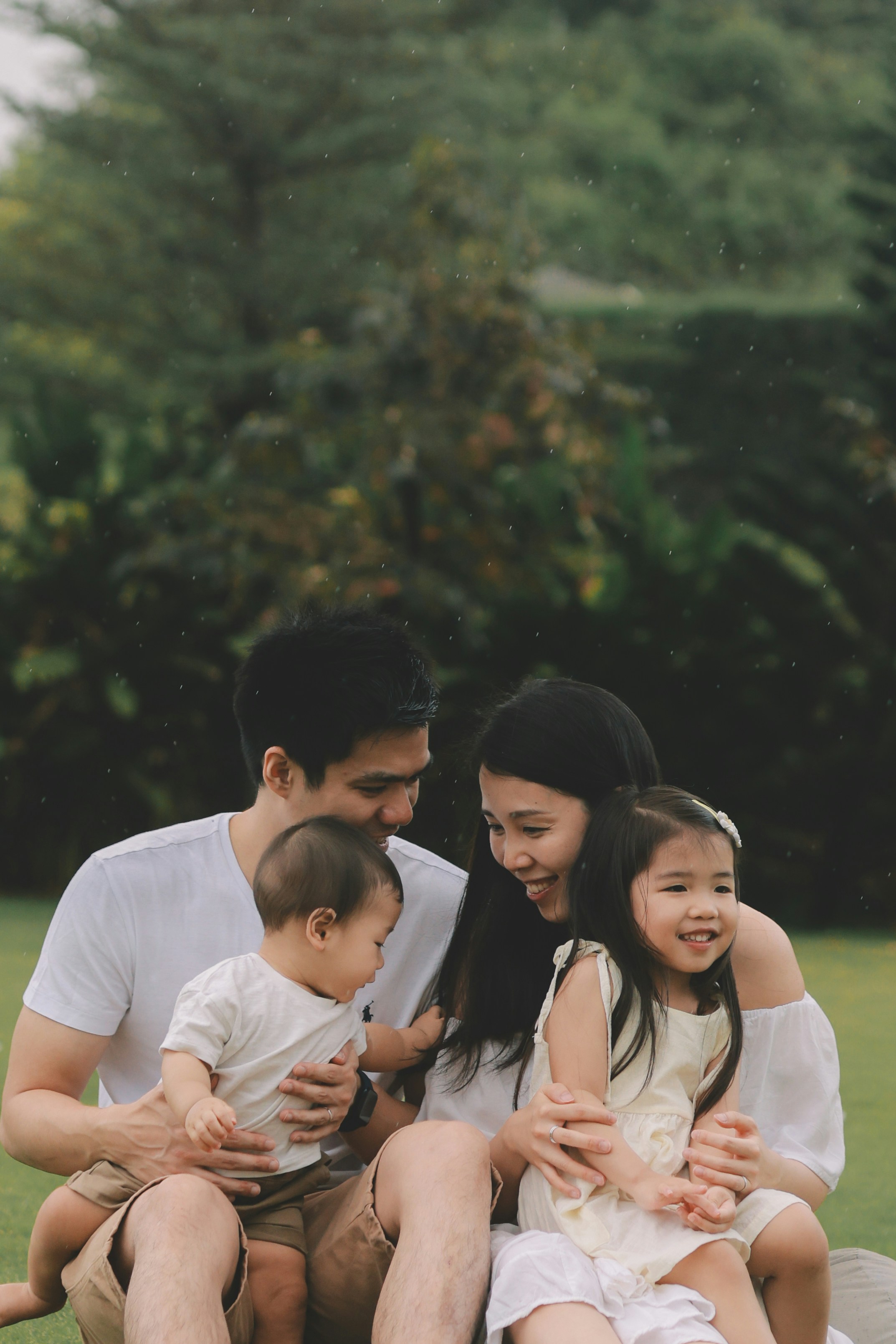 A happy family of four sitting together outdoors