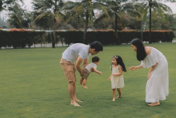 Family playing together on a grassy lawn