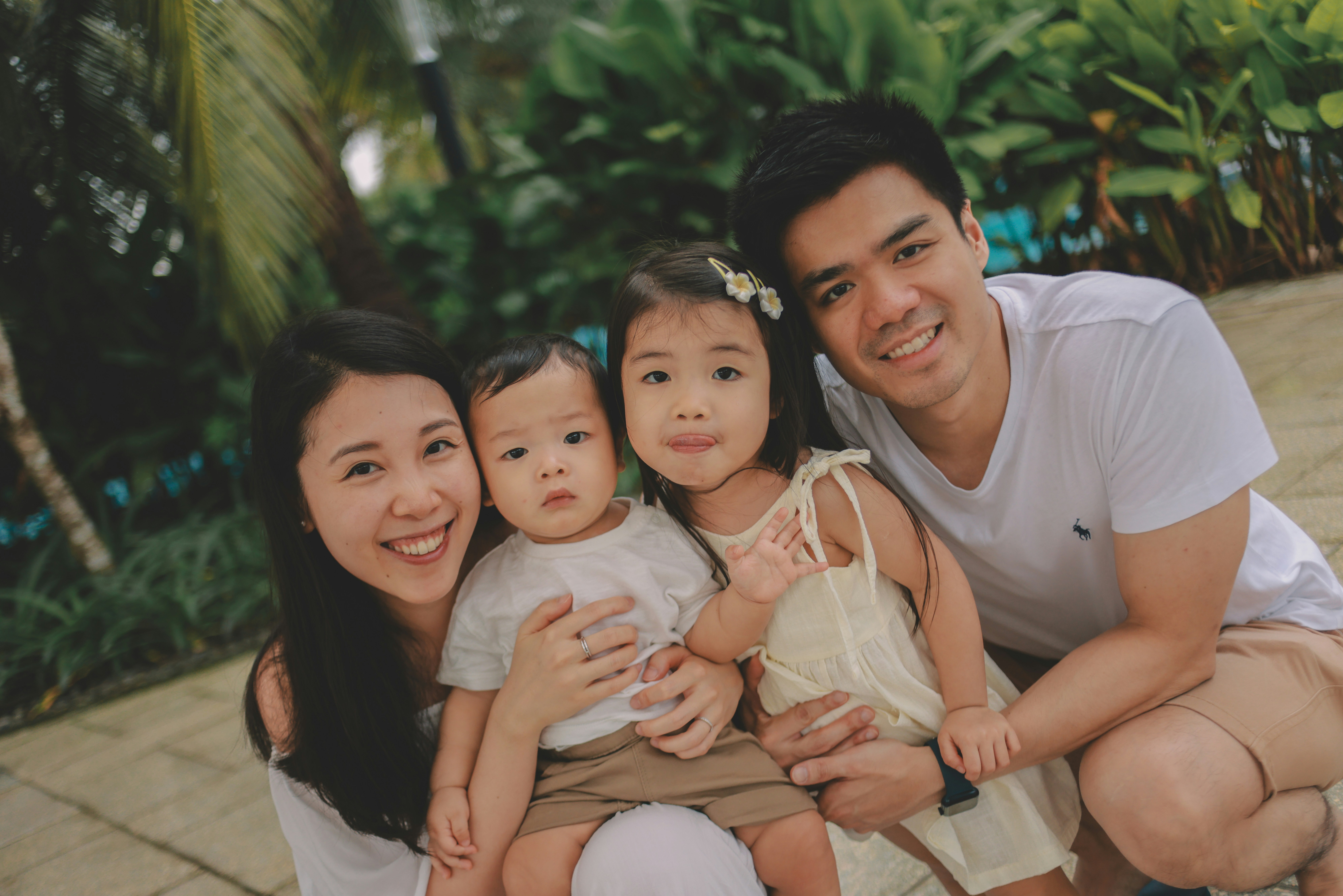 A family of four posing for a picture outdoors.