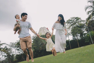 A happy family running together on grassy hill