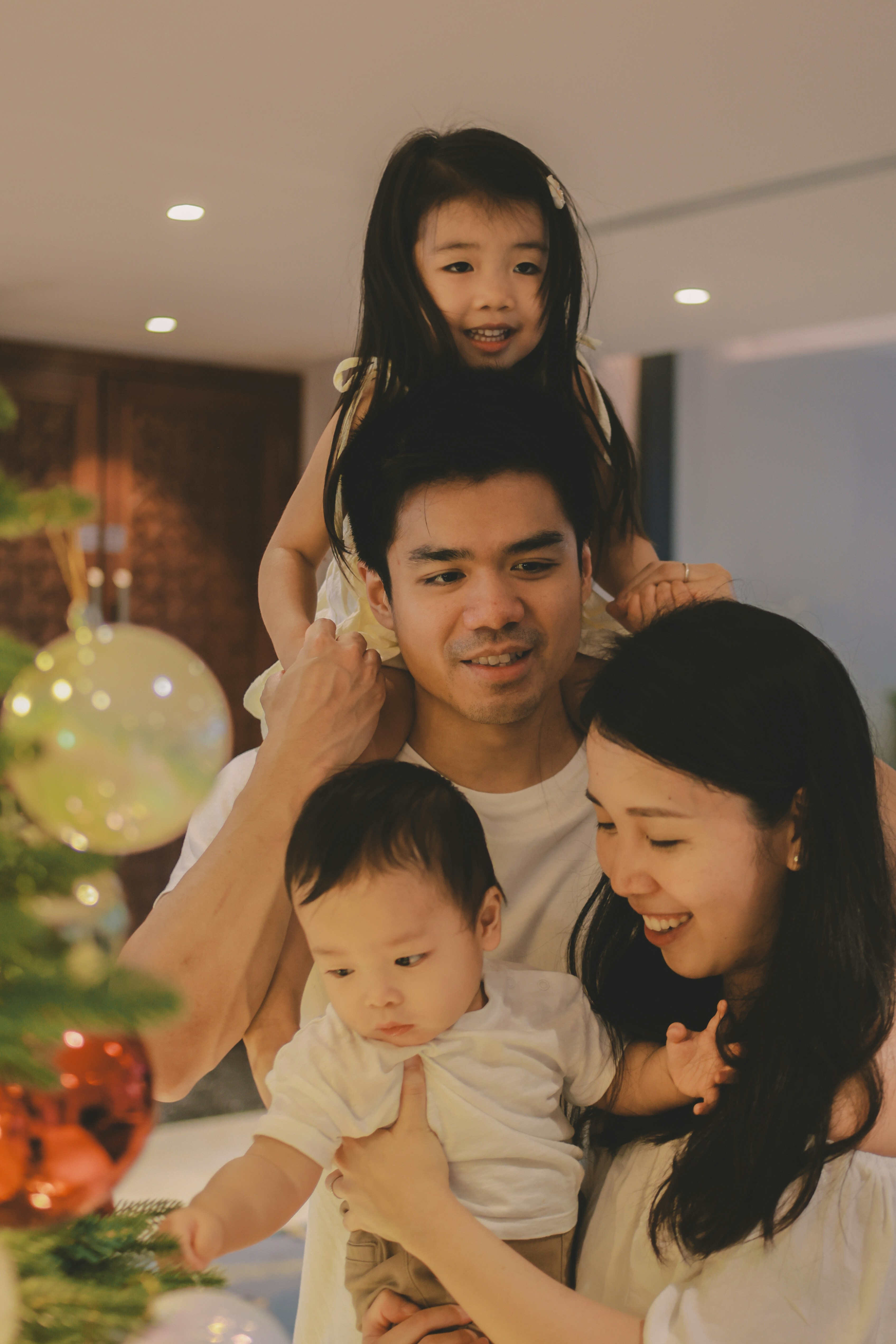Family decorating a christmas tree together happily together