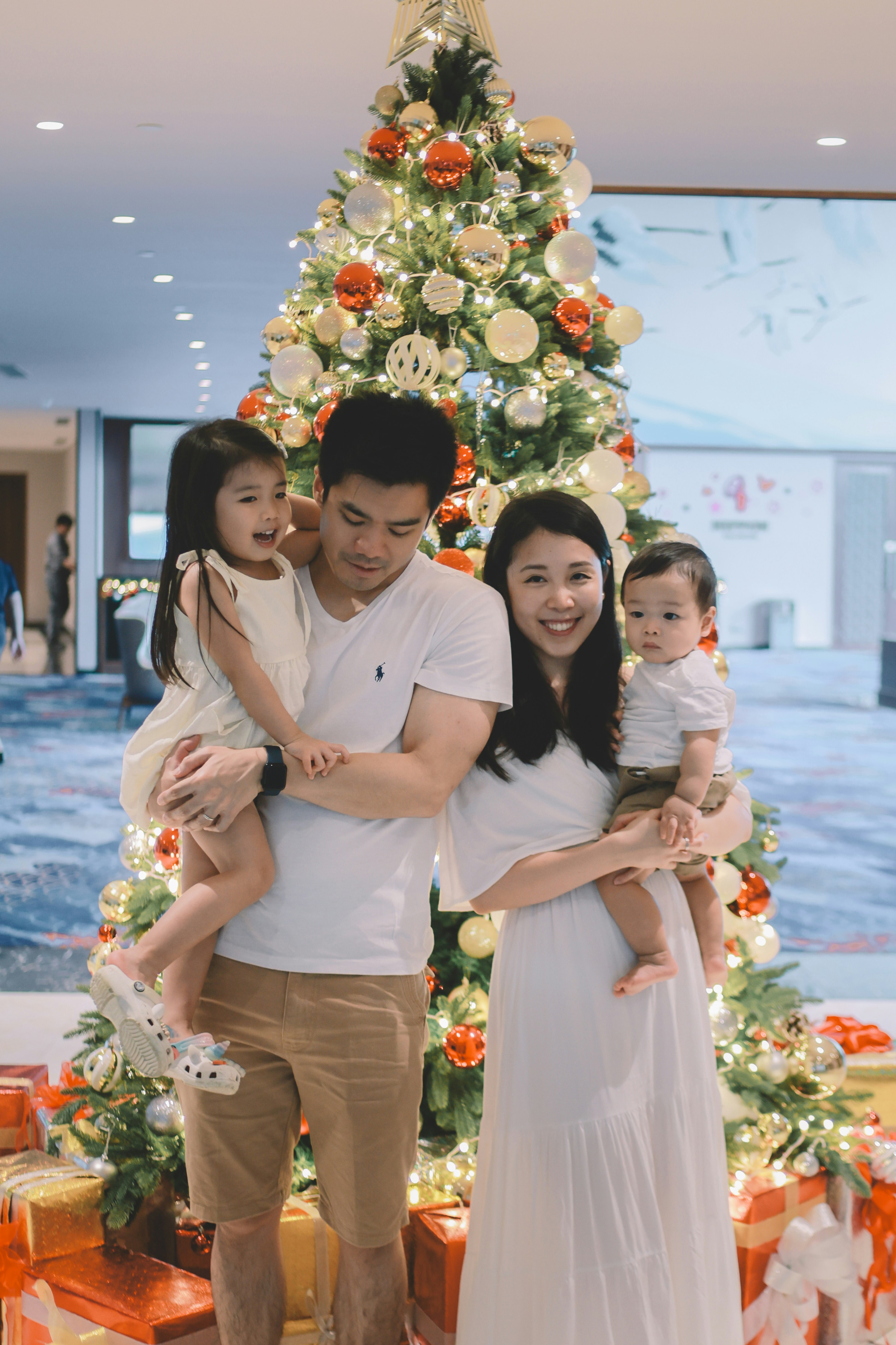 Family posing in front of a decorated christmas tree
