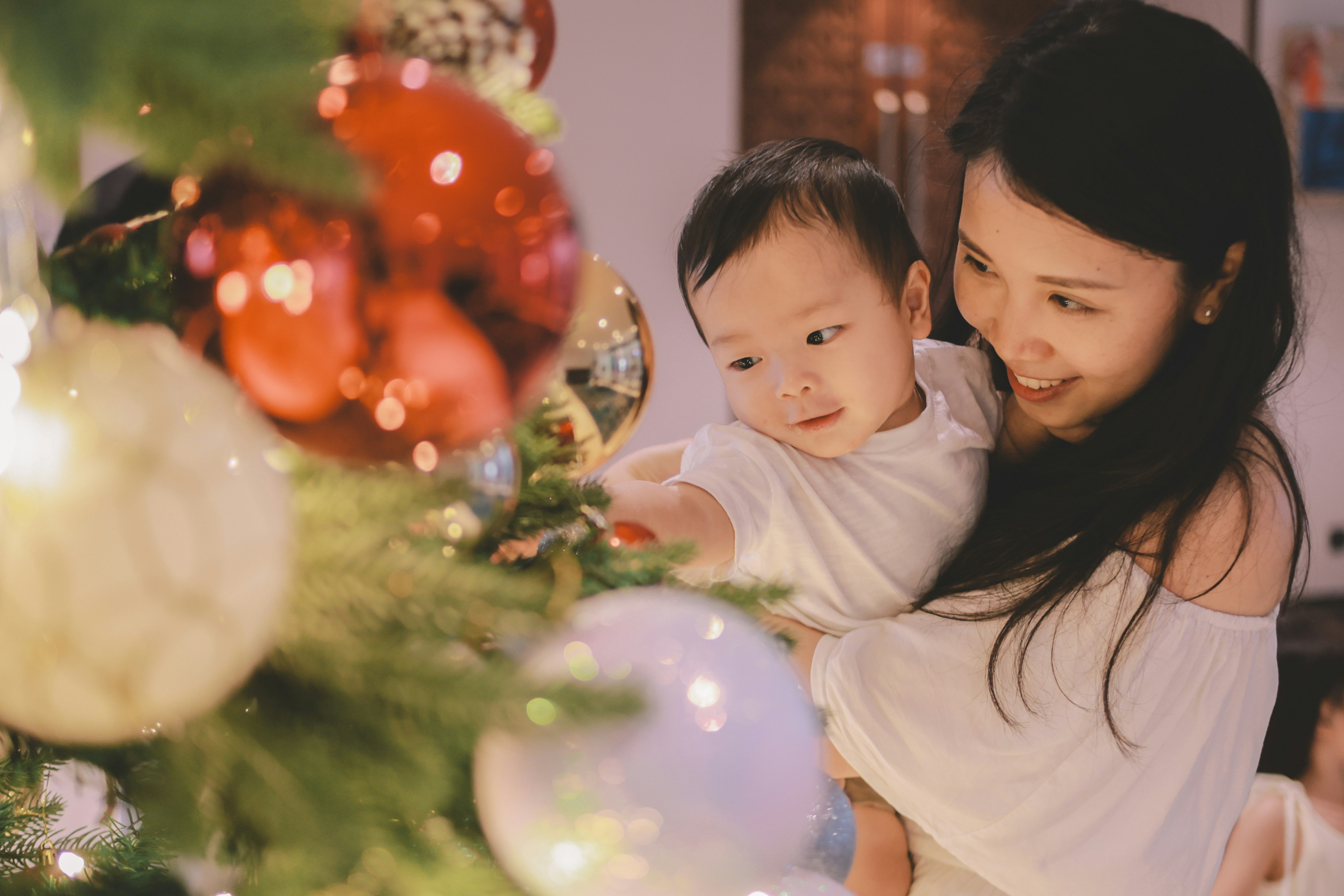 Mother and child decorating a christmas tree.