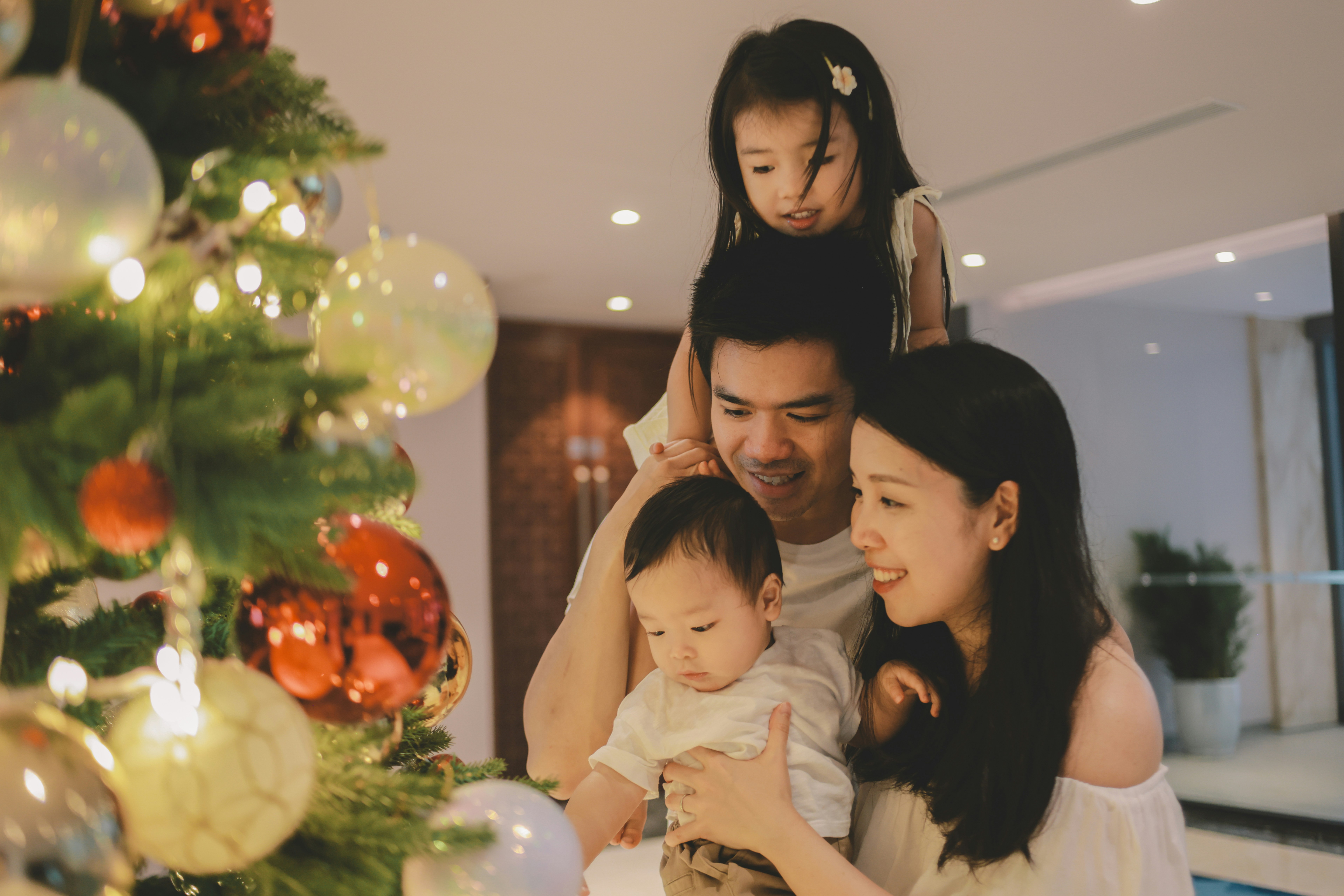 Family gathered around a decorated christmas tree.