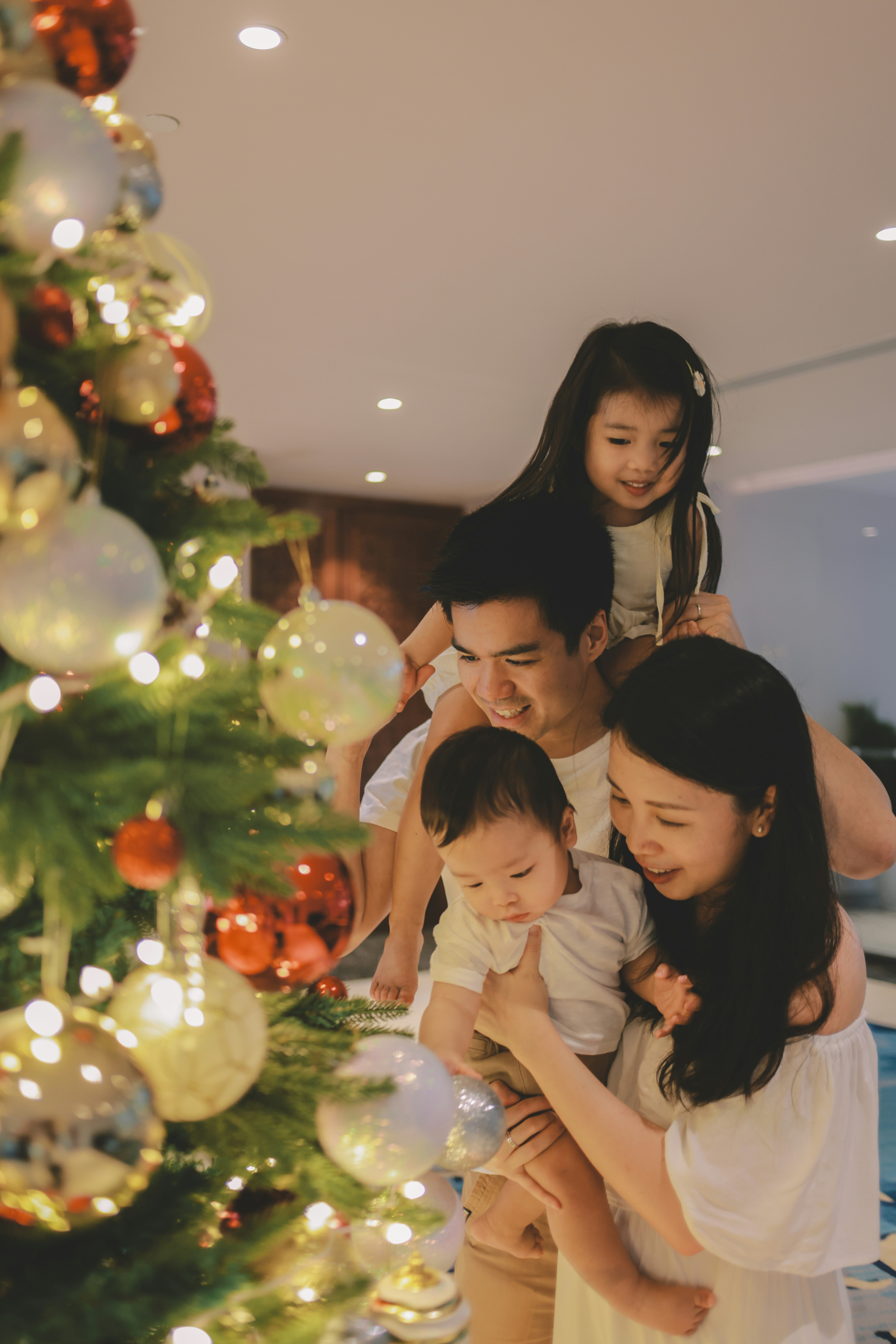 Family celebrating christmas by a decorated tree