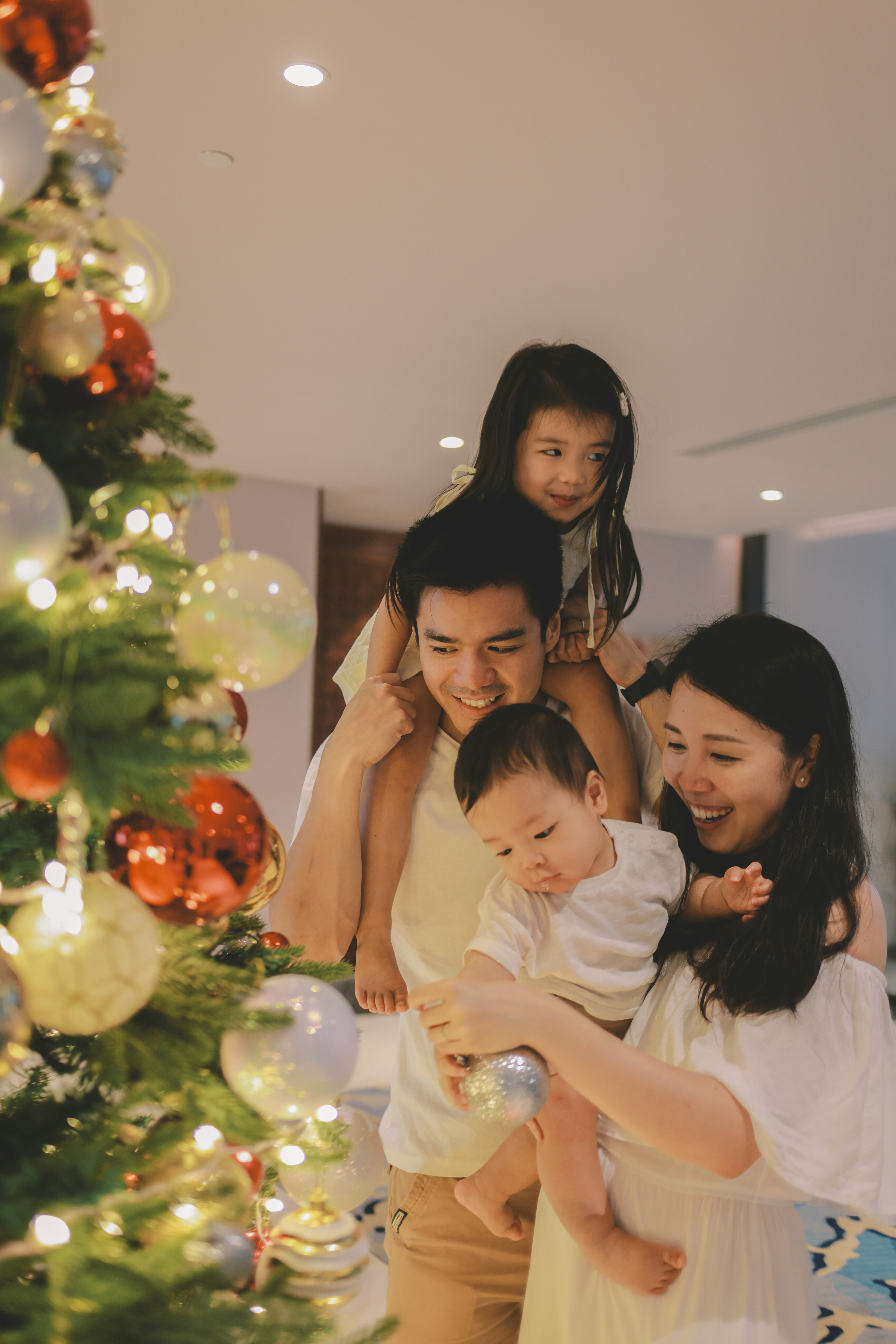 Family decorating a christmas tree together happily