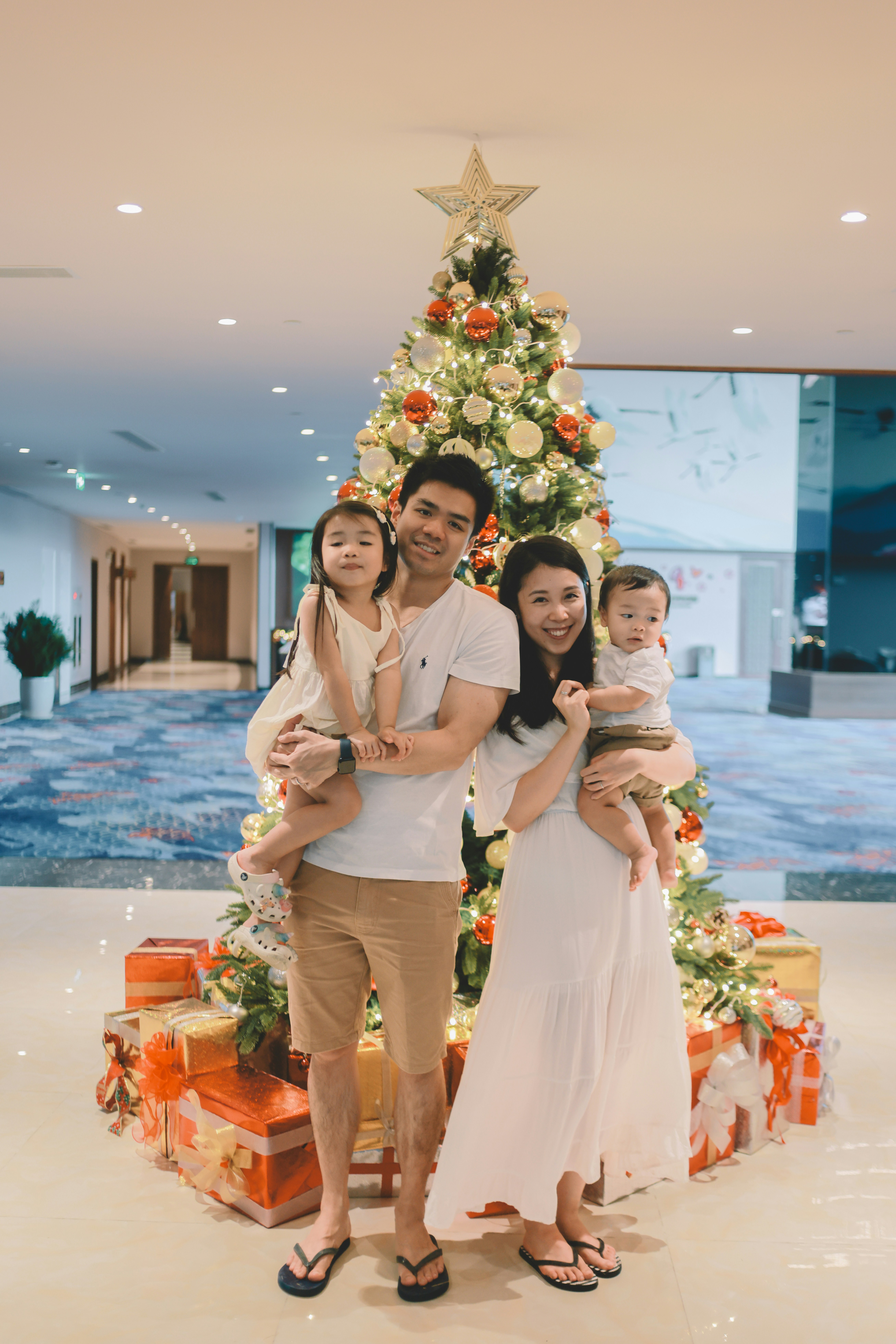 Family posing in front of a decorated christmas tree.