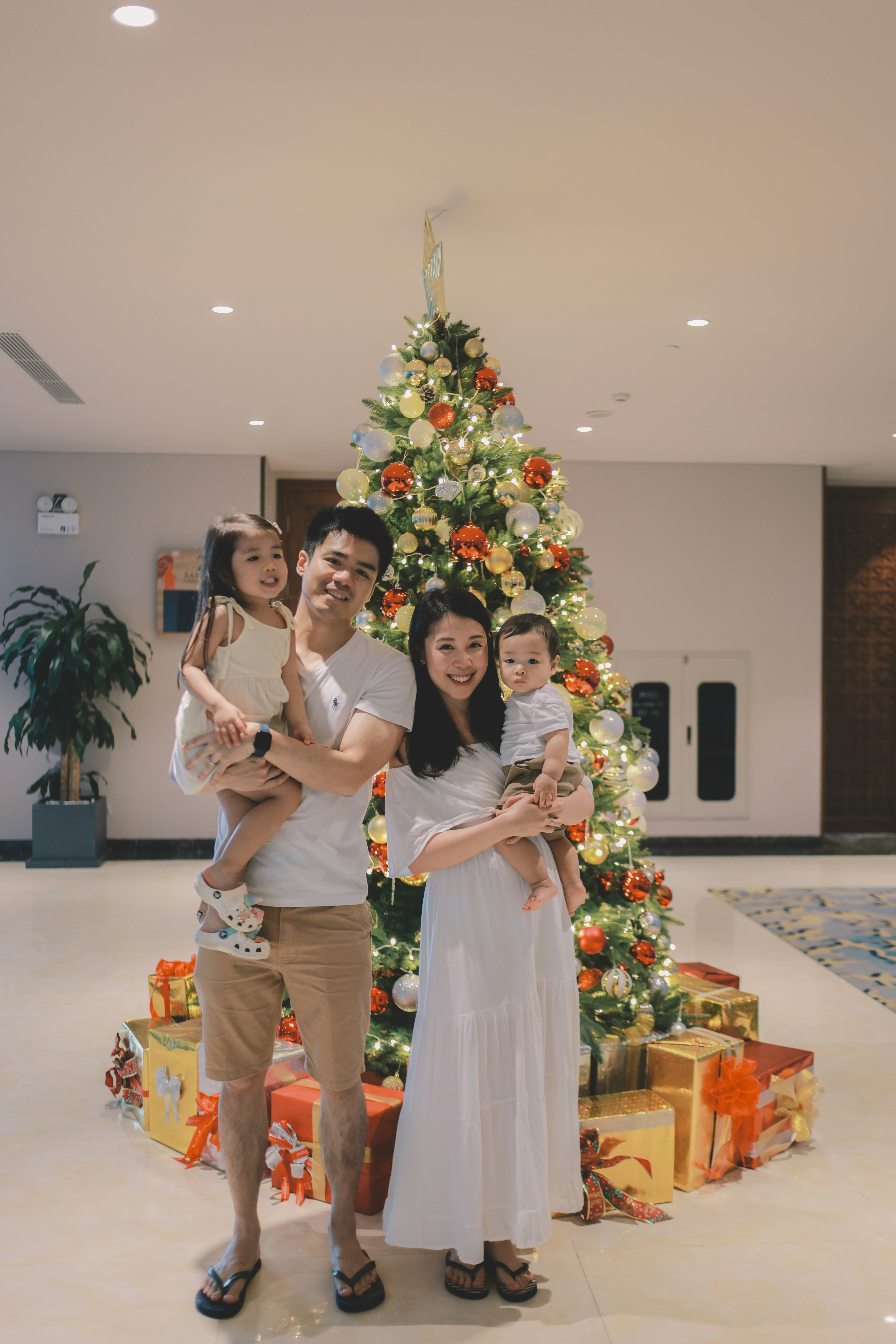 Family posing in front of a decorated christmas tree.