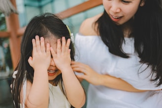 A mother and daughter playing peek-a-boo