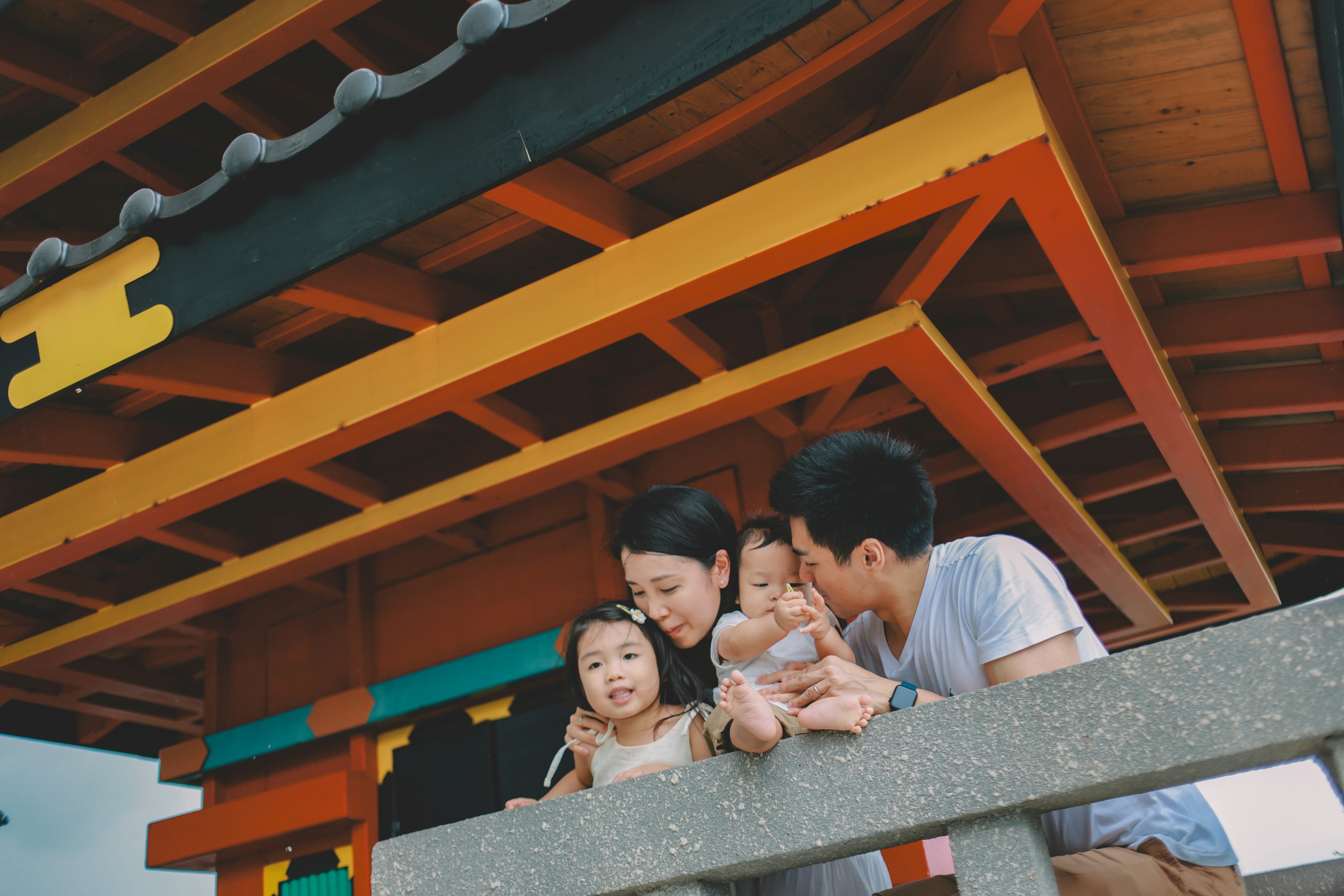 Family posing for a picture under colorful roof