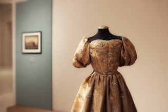 Ornate golden dress displayed on a mannequin