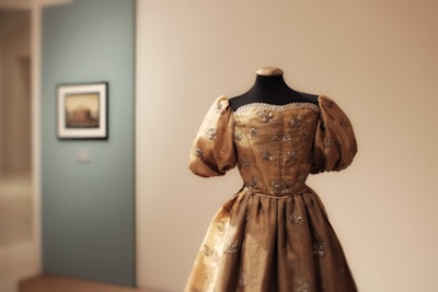 Ornate golden dress displayed on a mannequin