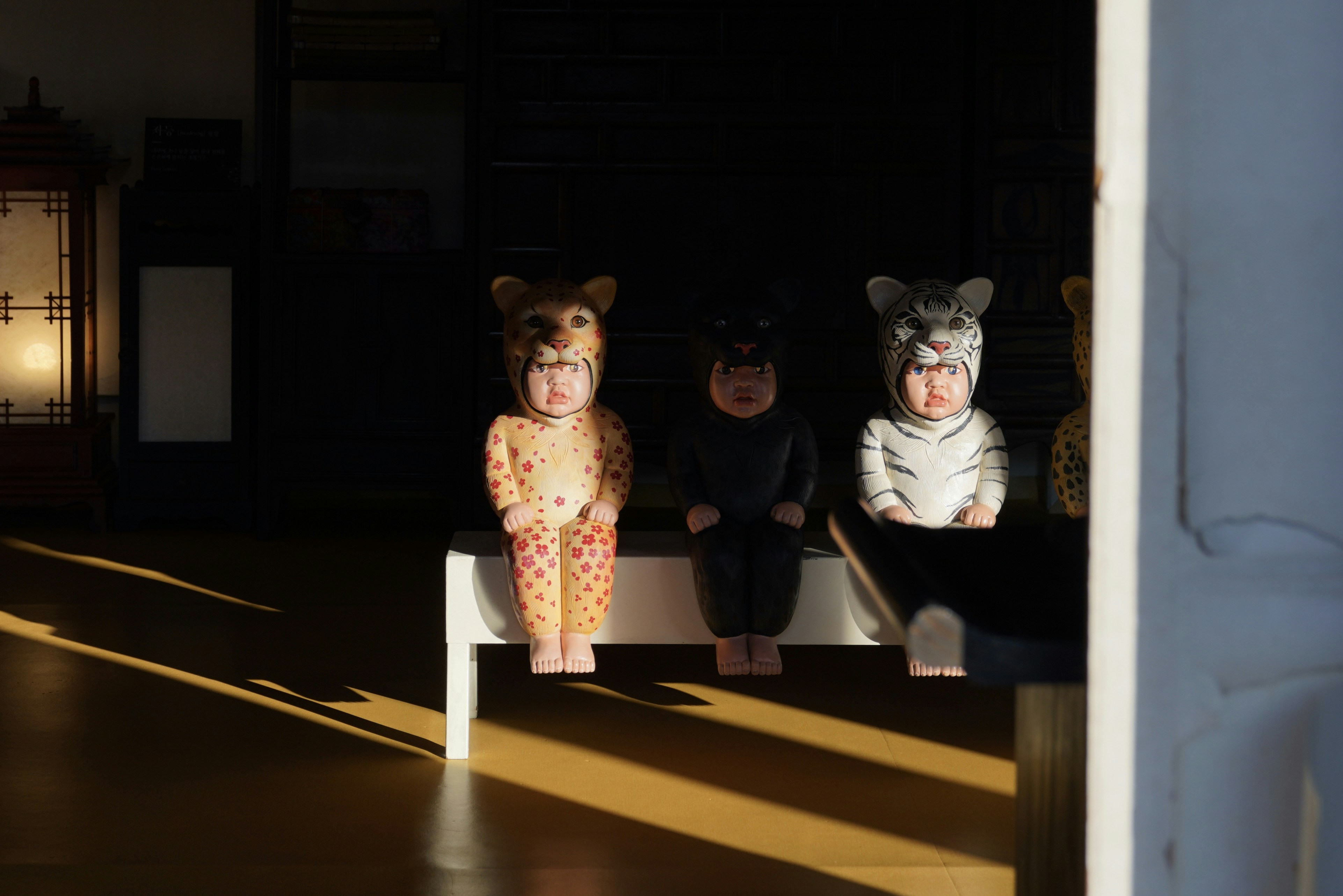 Three wooden animal figures sit in sunlight