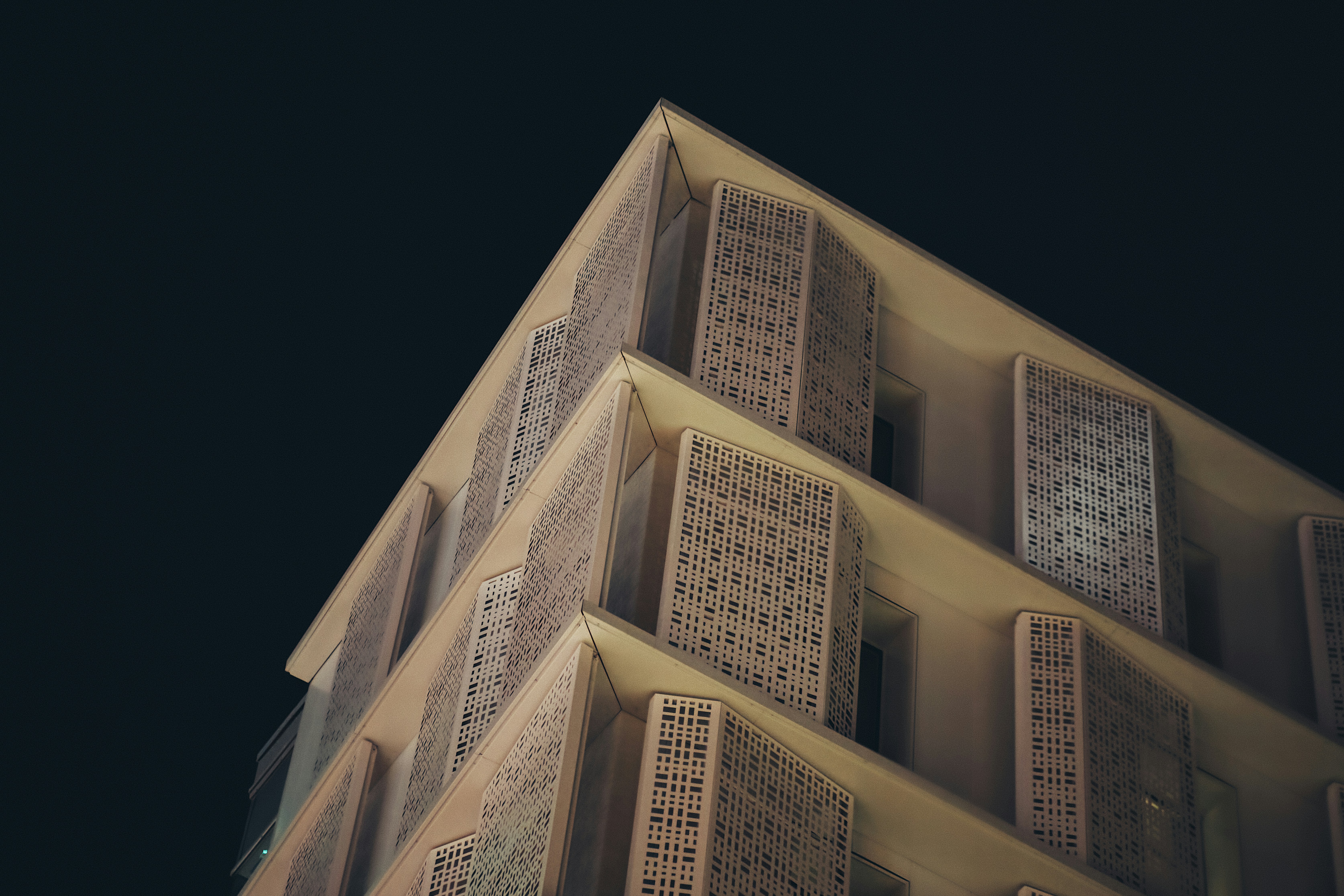 Modern building facade with patterned windows at night