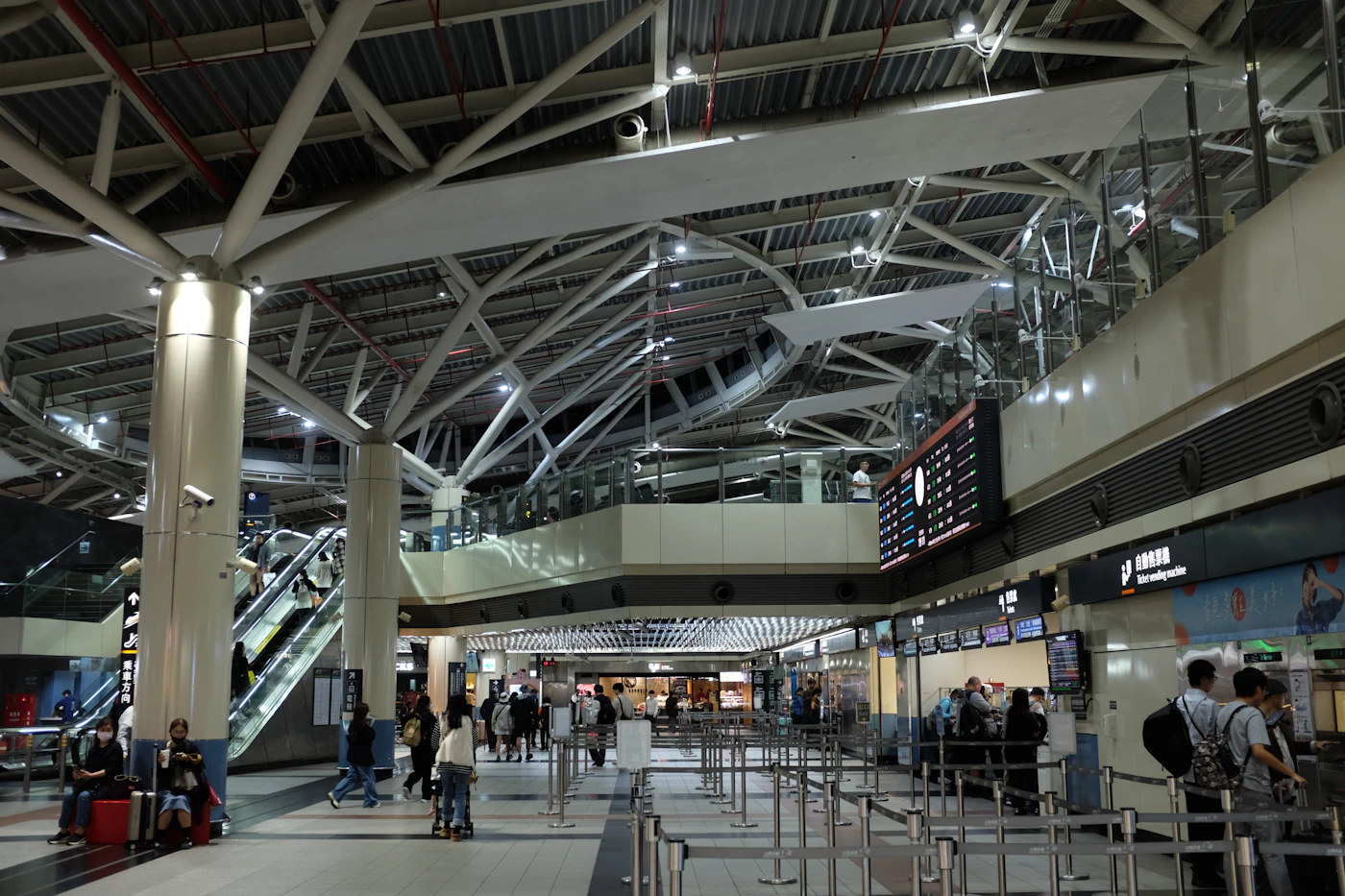 Terminal d’aéroport avec escalators et panneaux de départ