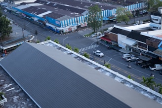 Aerial view of a street intersection with buildings and cars.