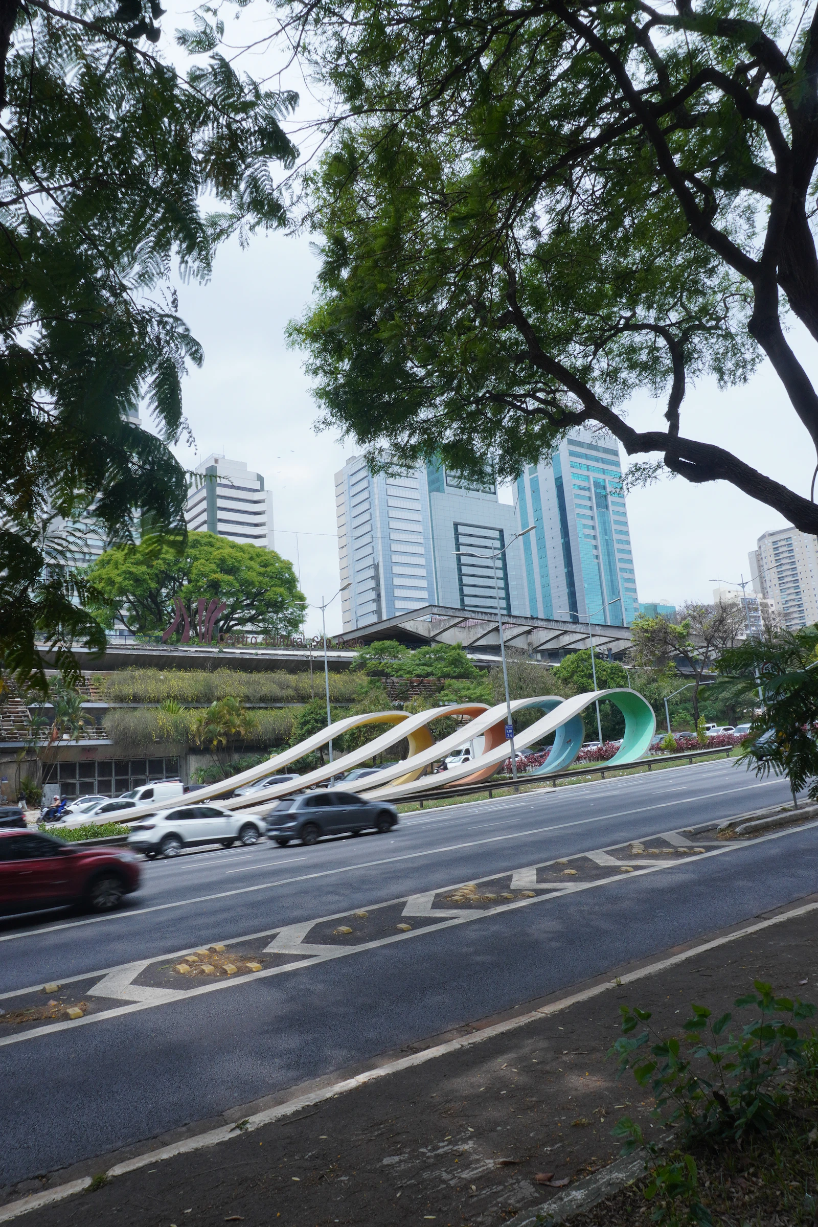 Cars passing modern buildings on a São Paulo city road