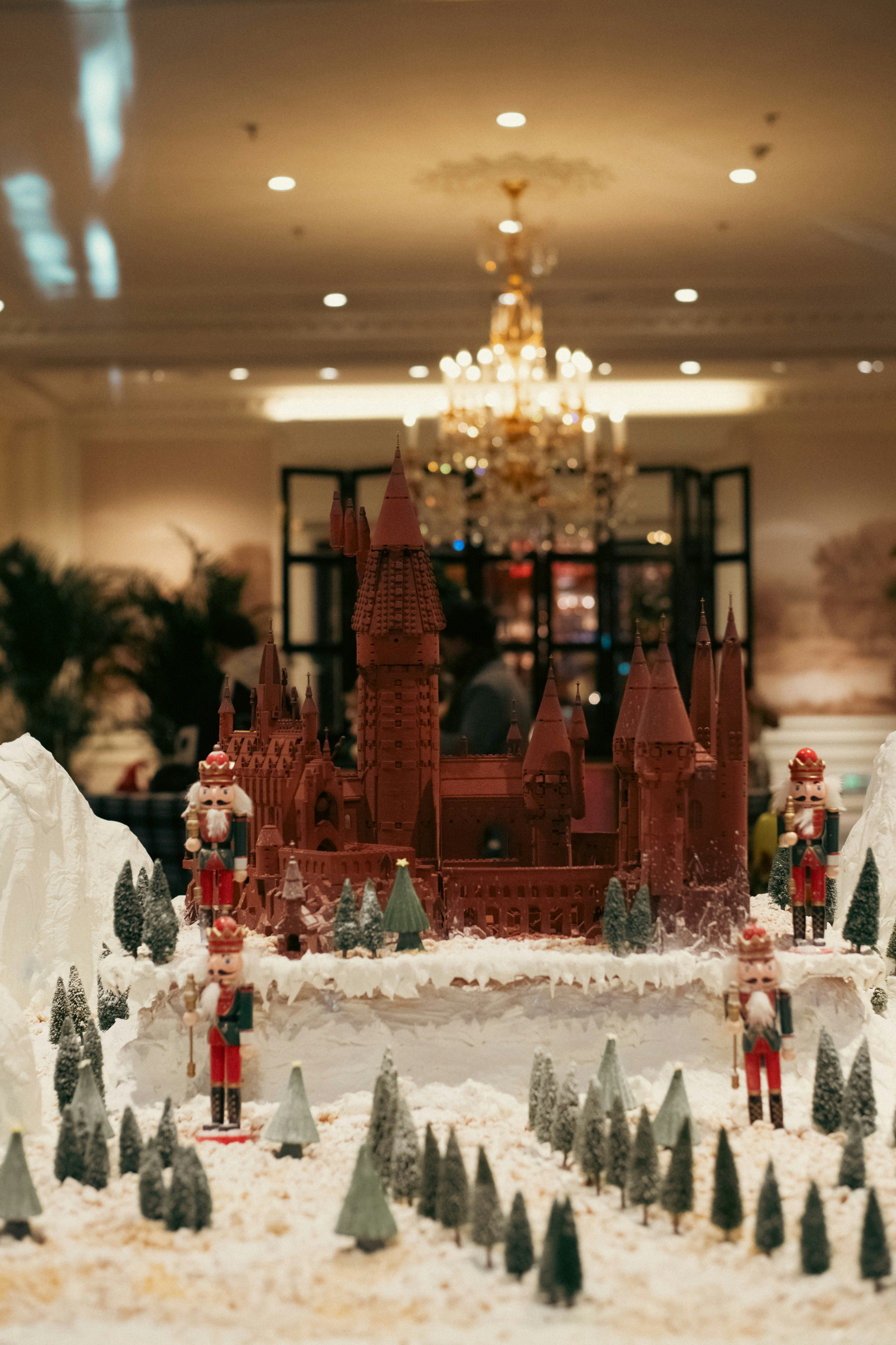 Schokoladenschloss, umgeben von Nussknackern und verschneiten Bäumen