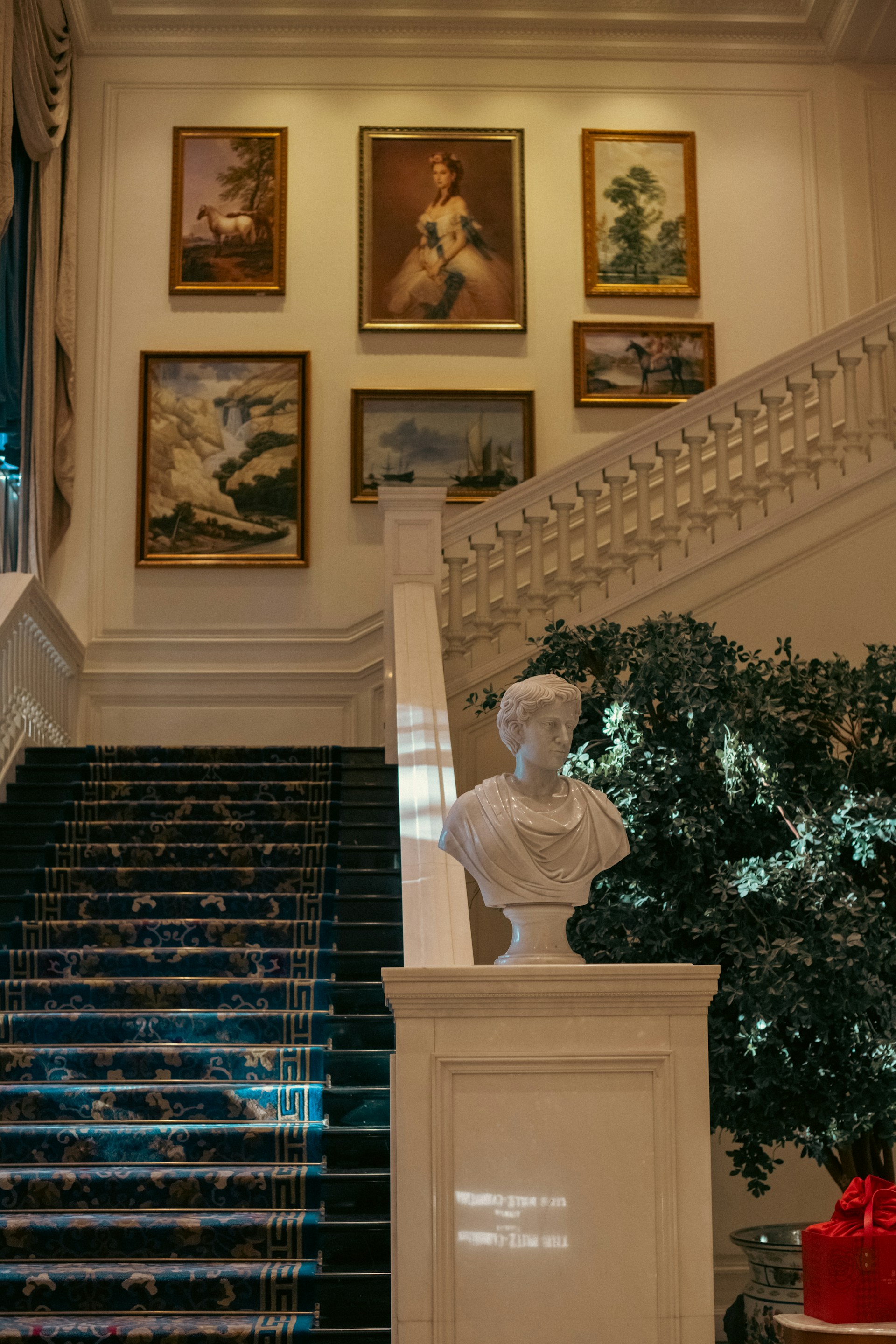 Grand staircase with paintings and bust