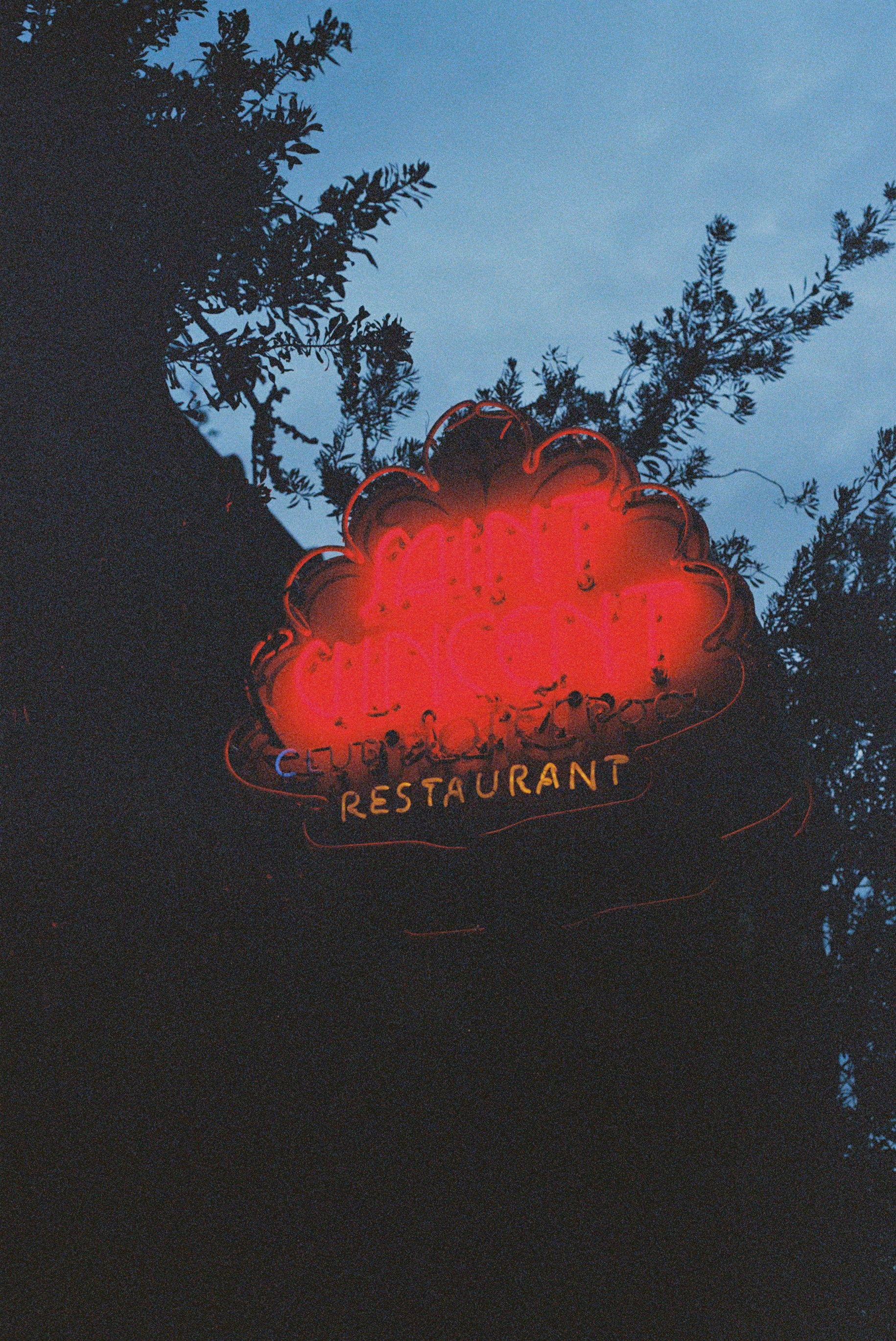 Red neon restaurant sign glowing at dusk
