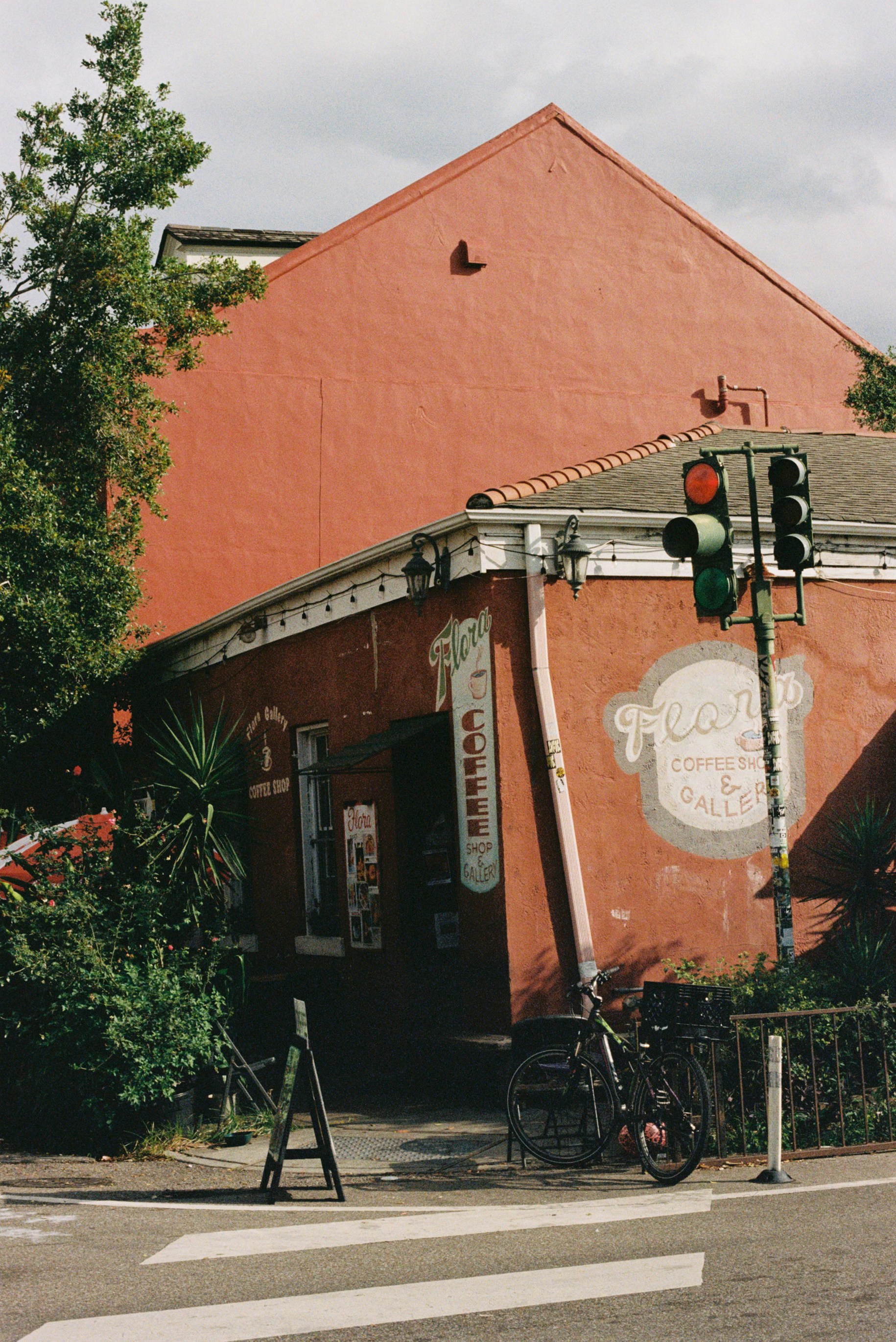 Red building with a coffee shop and bicycle.